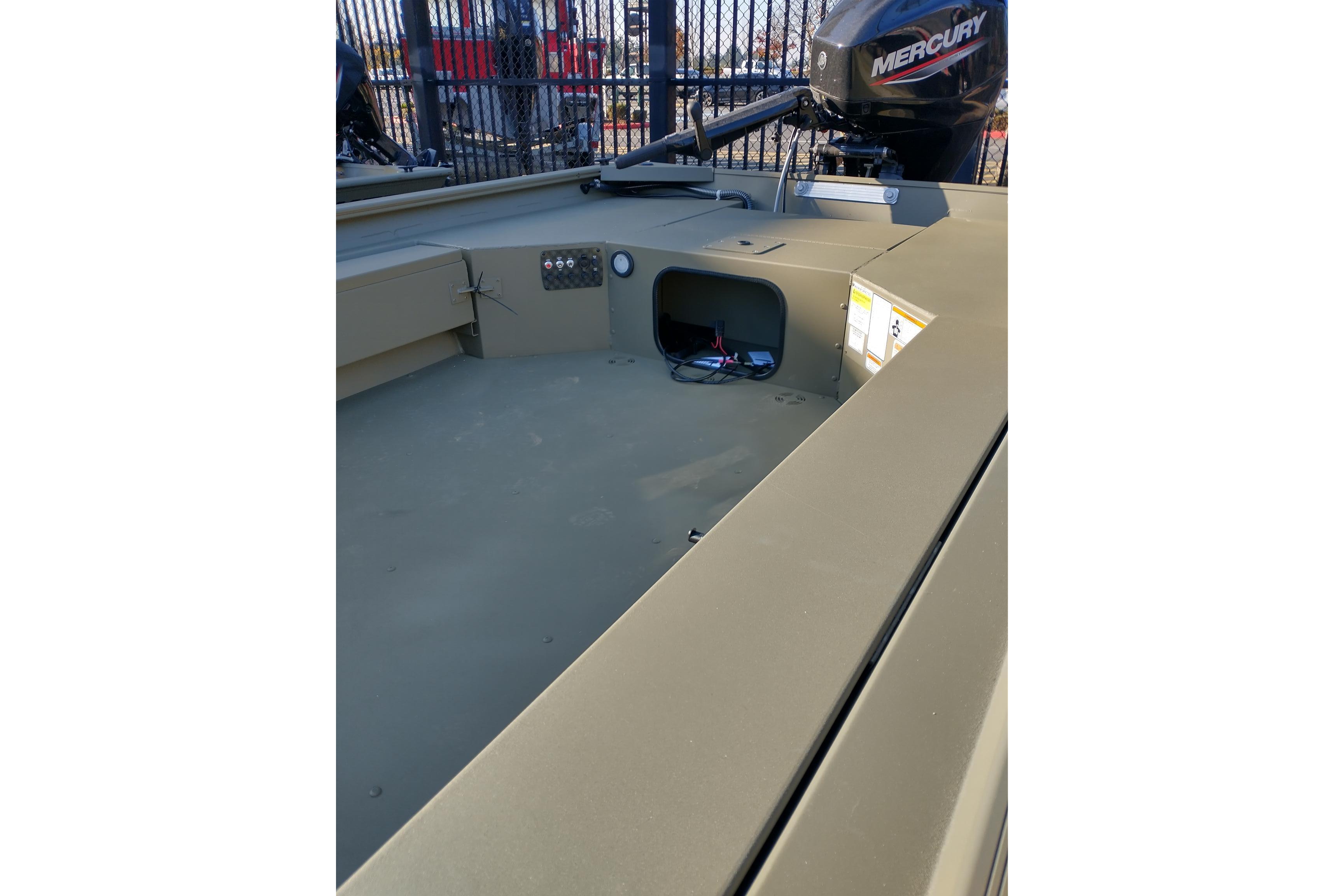 2026 Tracker Grizzly 1654 T Sportsman boat interior with Mercury engine, showcasing storage compartment.