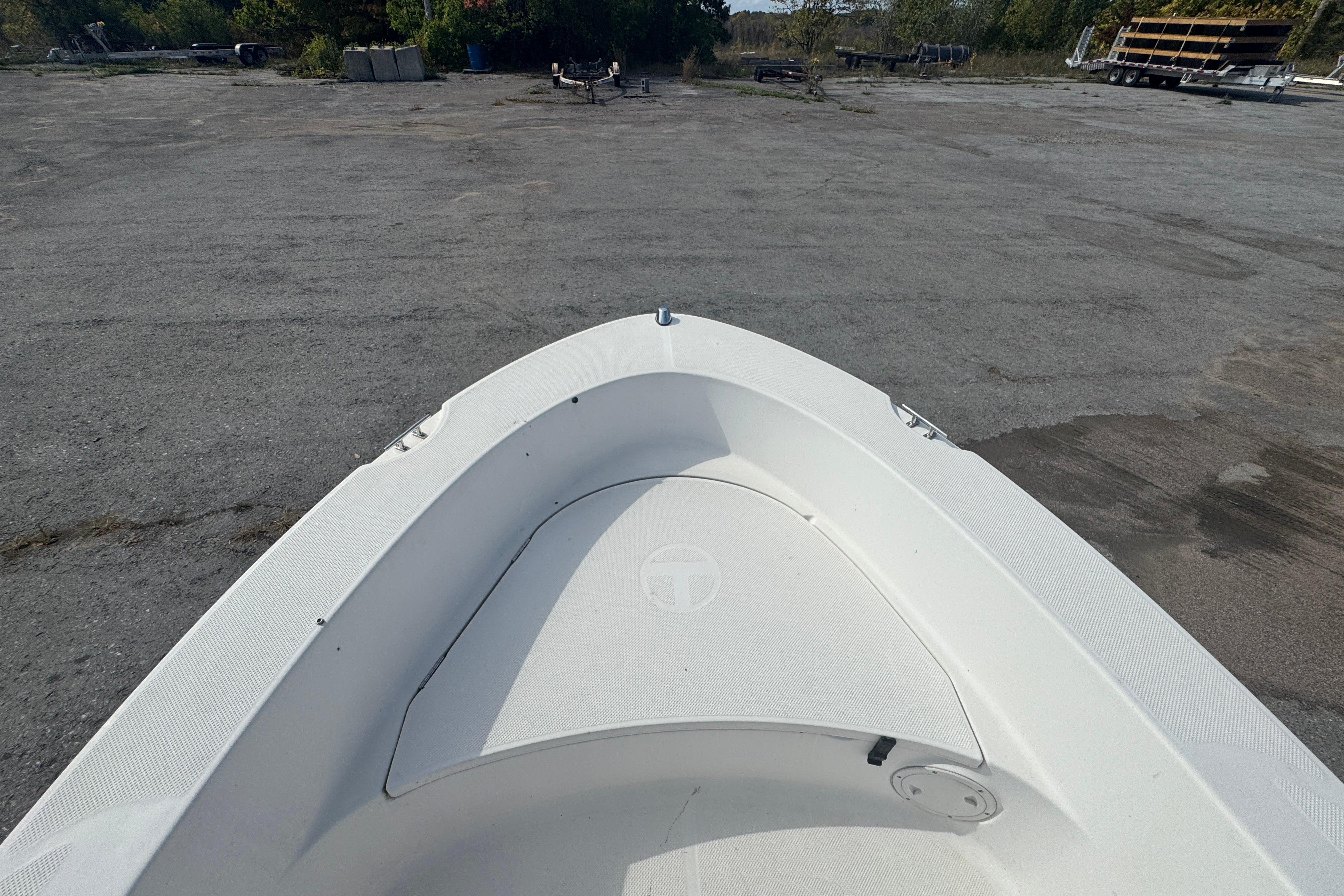 2007 Trophy 1703 Center Console boat on a paved surface, surrounded by greenery.