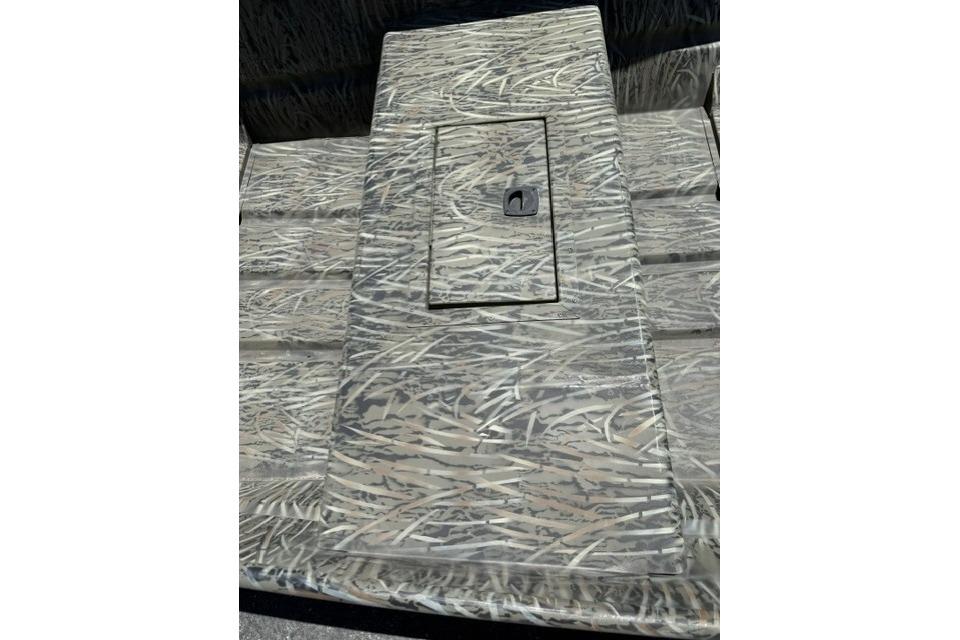 2026 Tracker Grizzly 15 Jon boat interior with camouflage pattern and storage compartment.