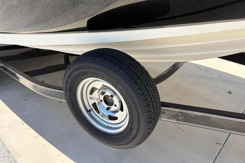 Trailer wheel of a 2007 Sea Ray 240 Sundeck boat on pavement.