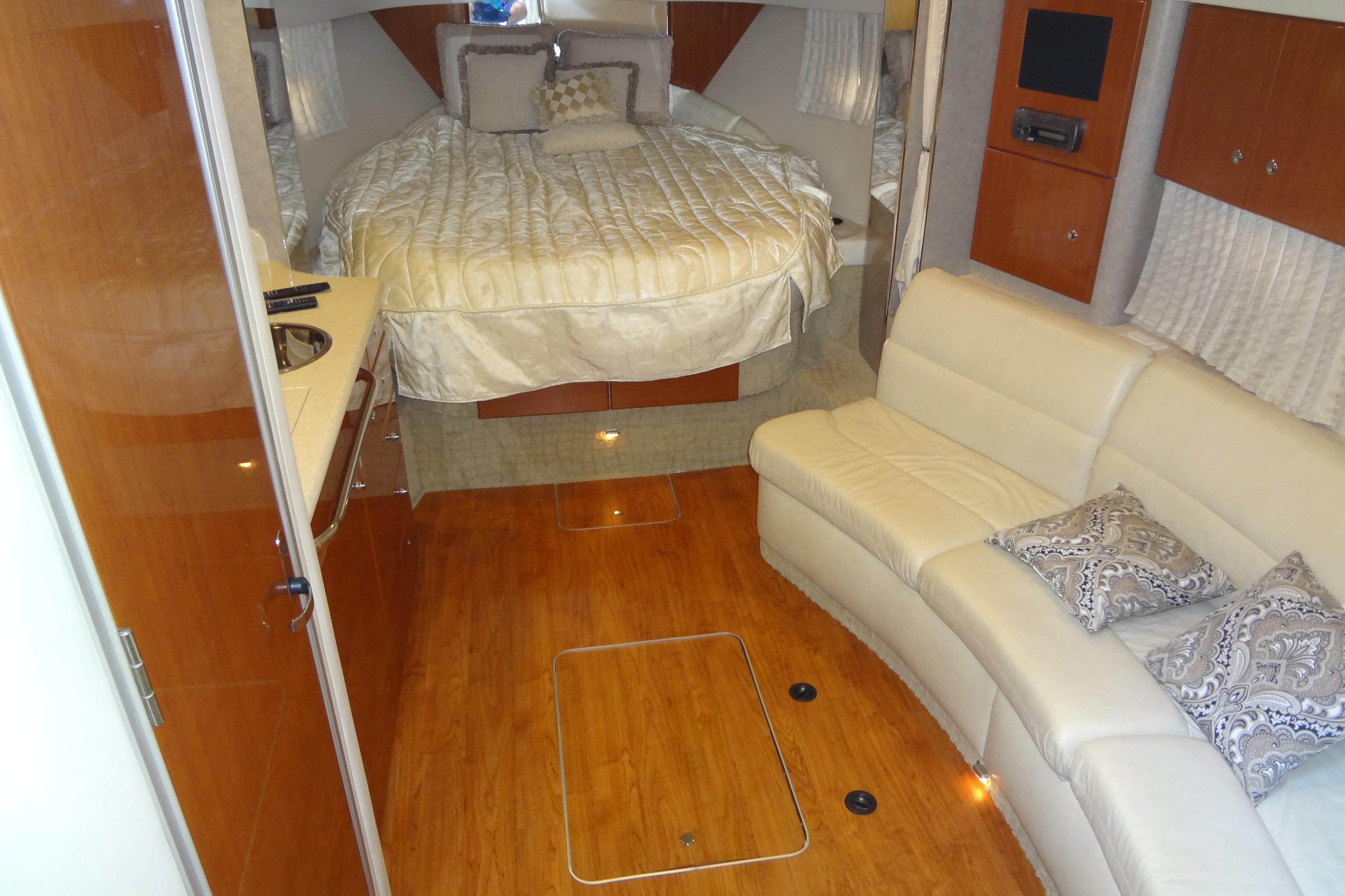 Luxurious interior of 2007 Formula 34 Performance Cruiser with bed, sofa, and wood flooring.