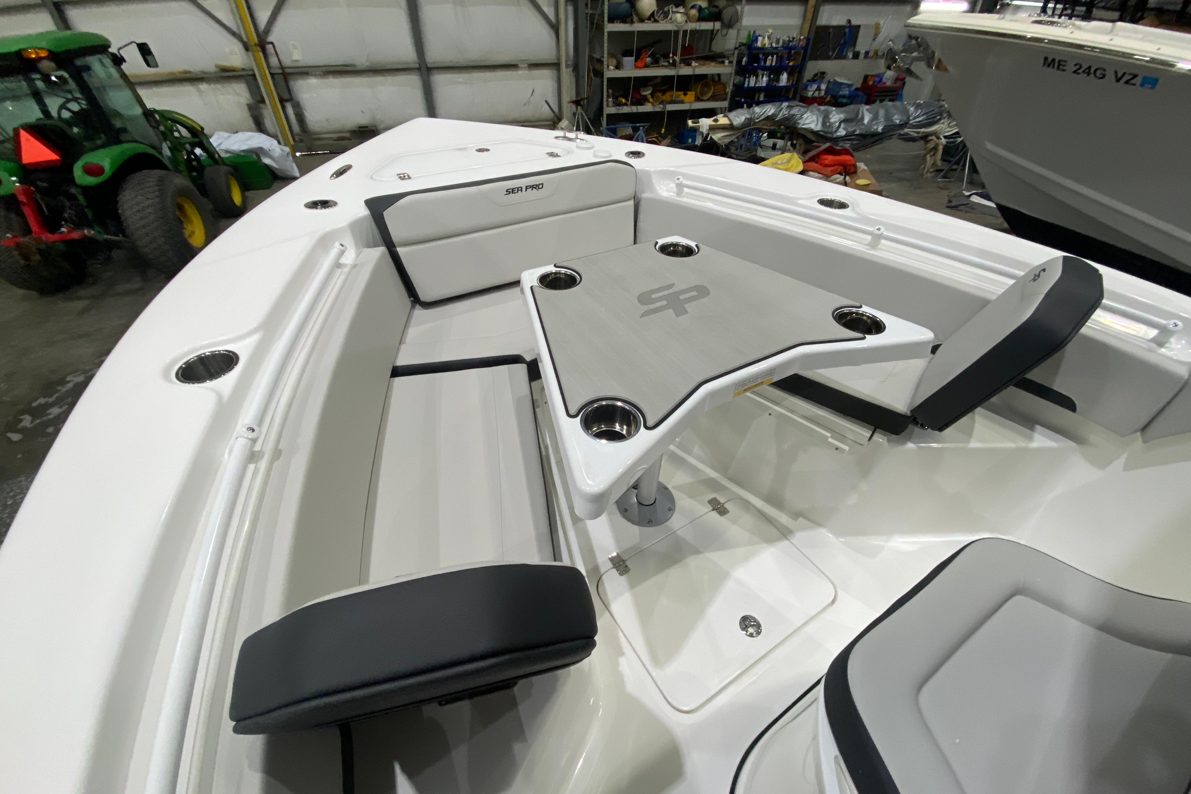 2027 Sea Pro 245FLXR Sandbar boat interior with seating and table in a garage setting.