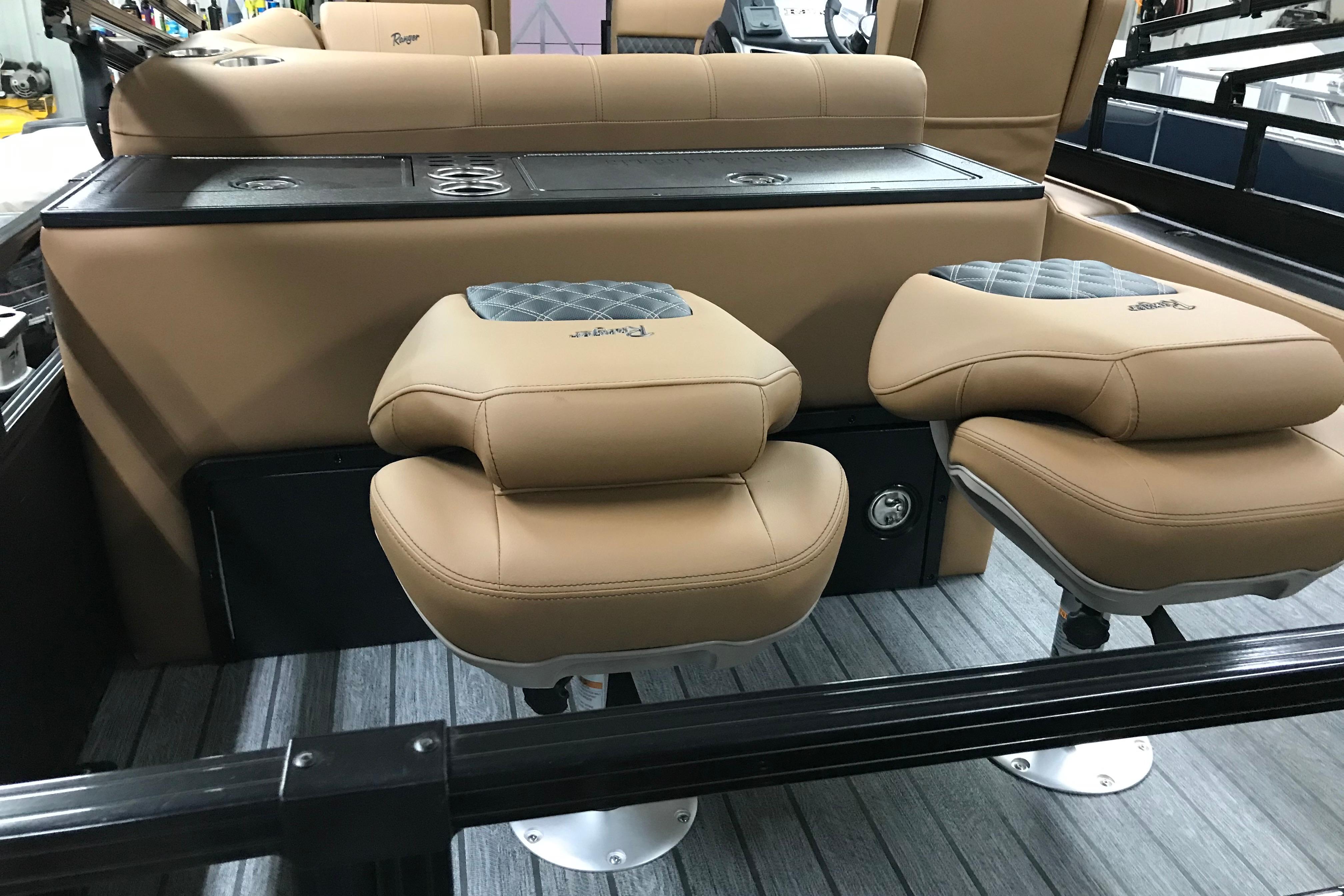 2026 Ranger Reata 220FC boat interior with tan cushioned seats and sleek design.
