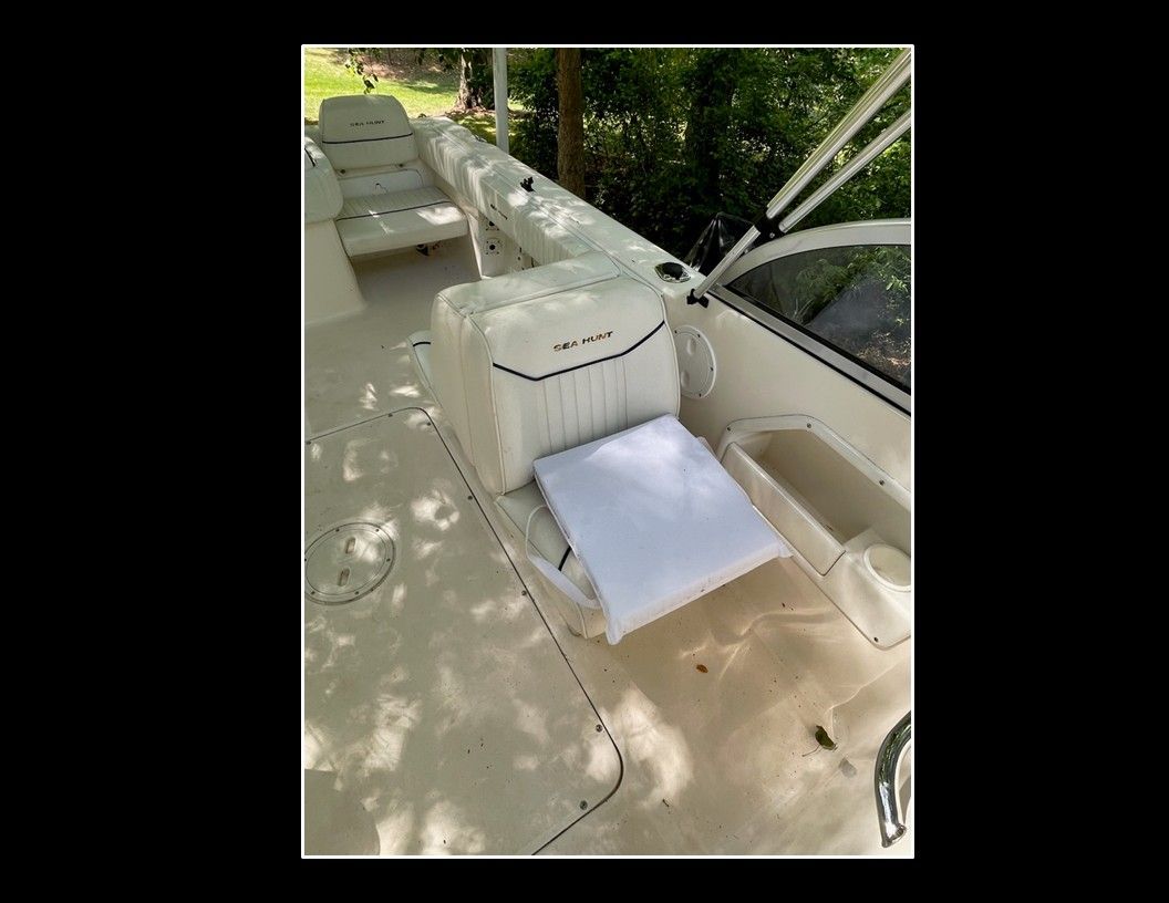 Interior of a 2004 Sea Hunt Escape boat with white seating and storage areas.