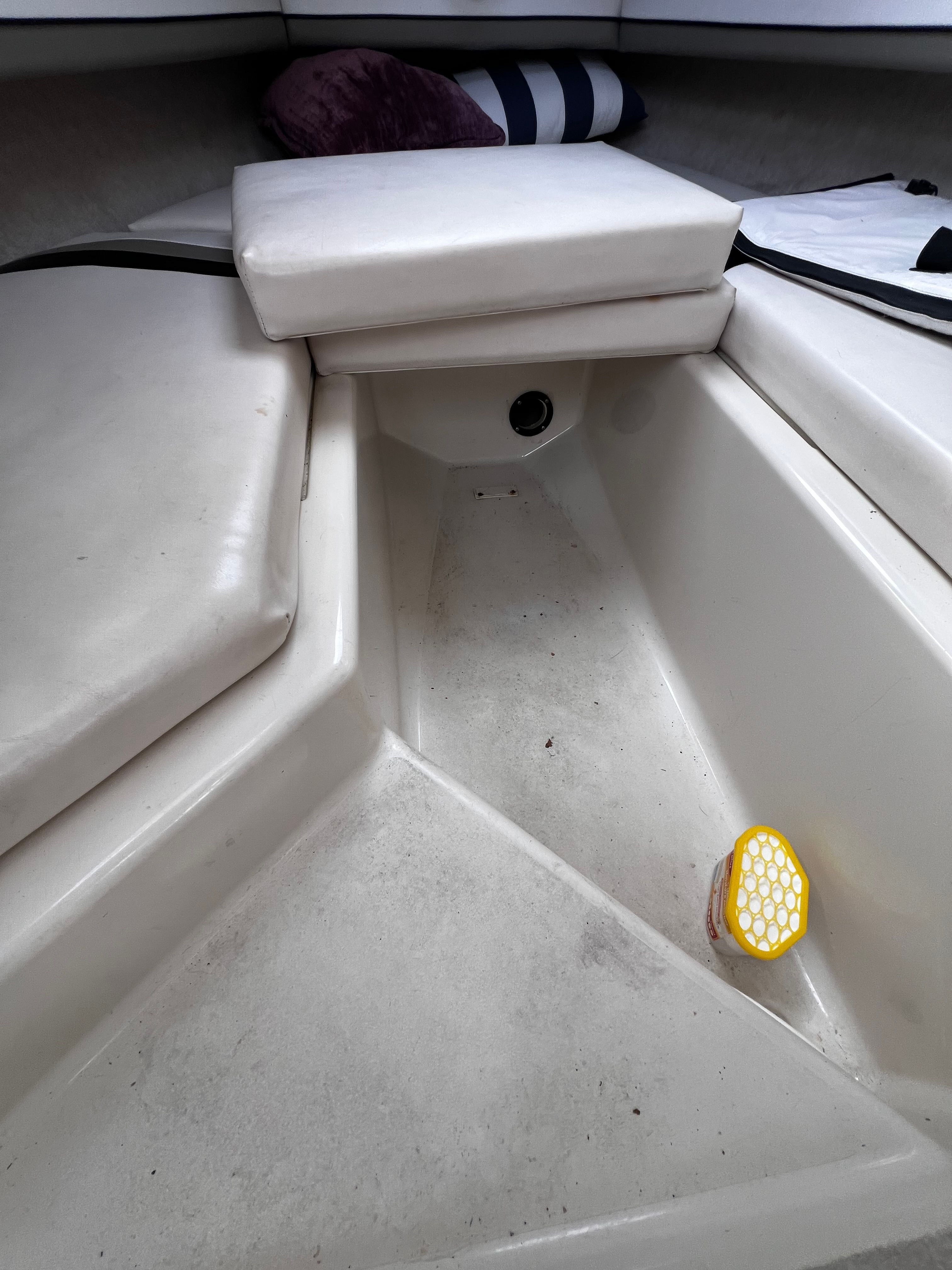 Interior of a 2001 Seaswirl Striper 1851 WA with white cushions and pillows.