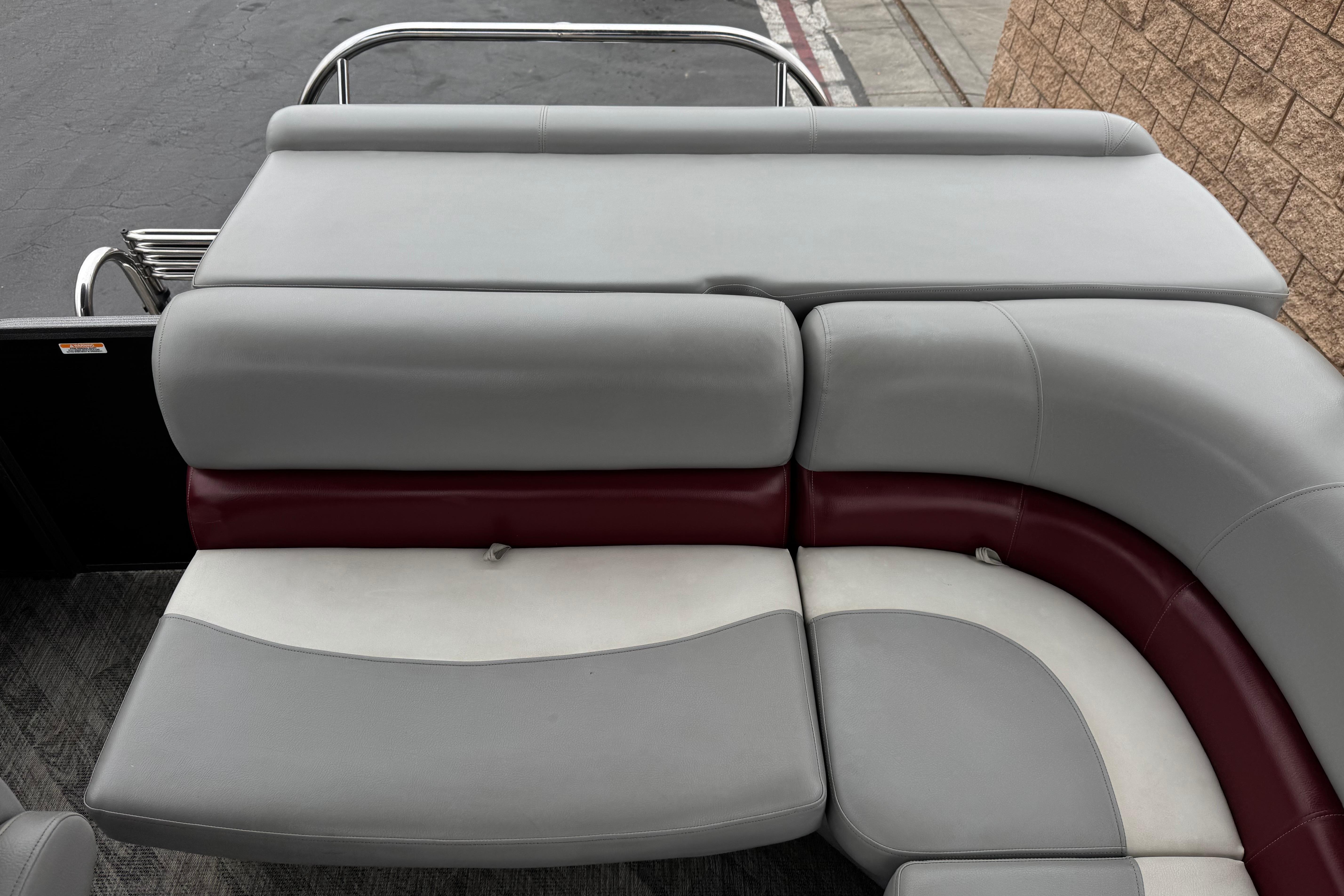 2020 Manitou 18 Aurora LE boat interior with gray and maroon seating.