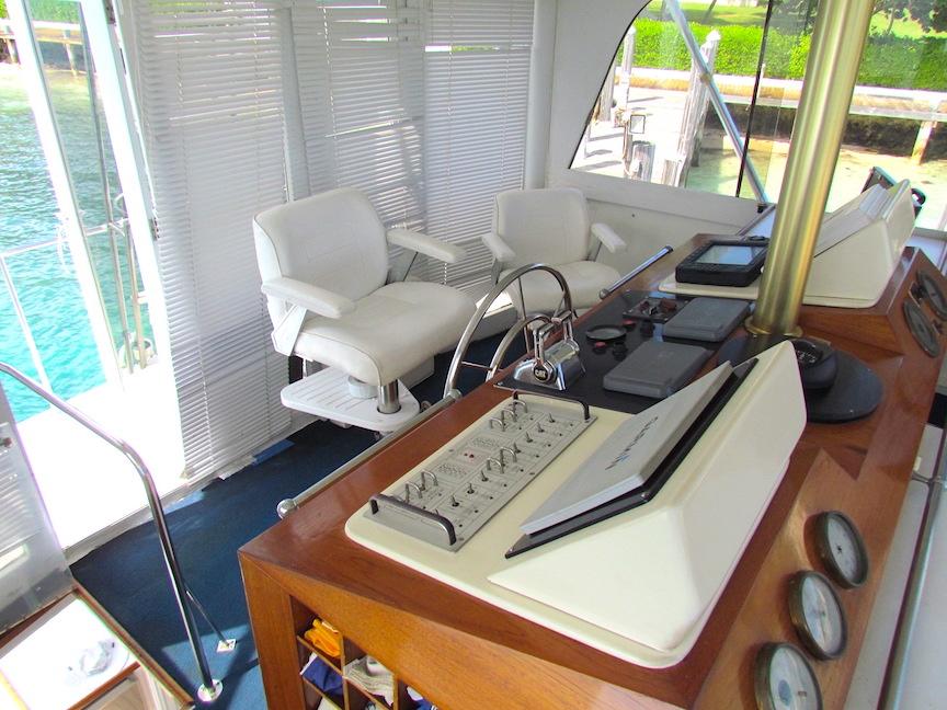 Interior helm of 1972 Hargrave 67 Motor Yacht with white chairs and control panel.