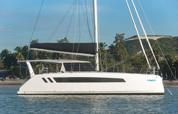2025 Seawind 1170 catamaran sailing on calm waters with tropical background.