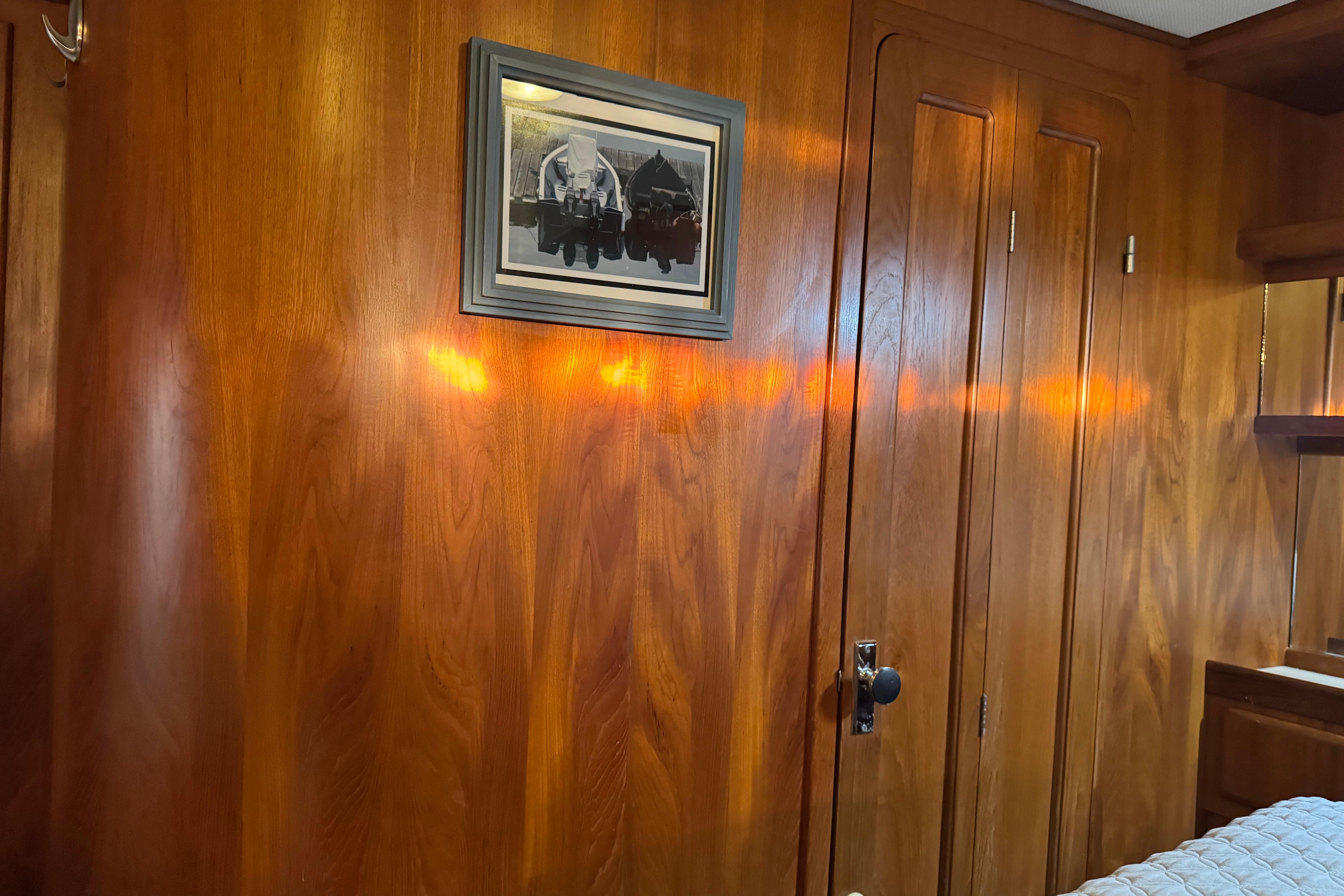 Wood-paneled room with framed artwork, featuring warm lighting and a closed door.