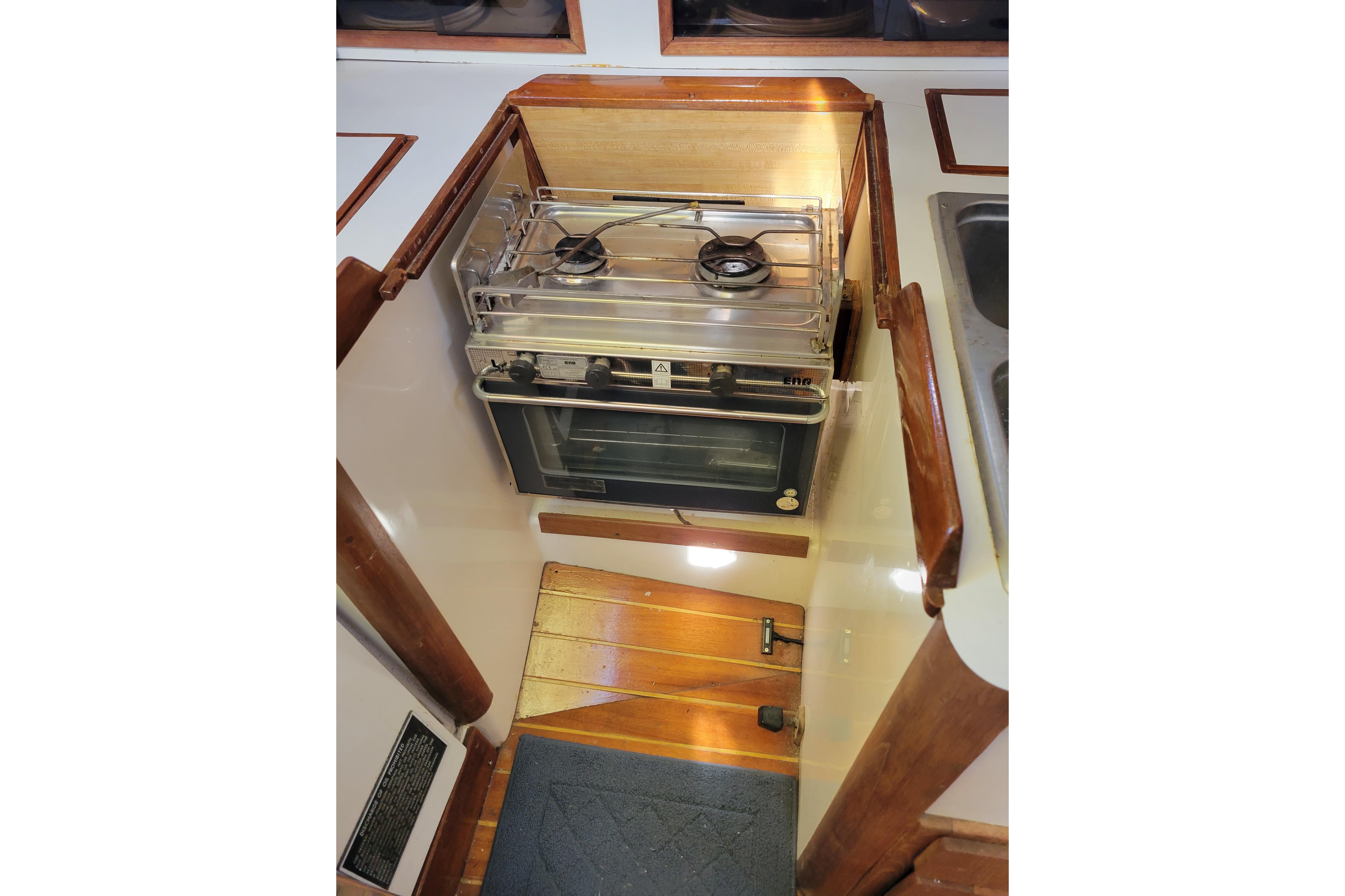 1981 Sea Sprite 34 yacht kitchen with stove and oven, featuring wooden accents.