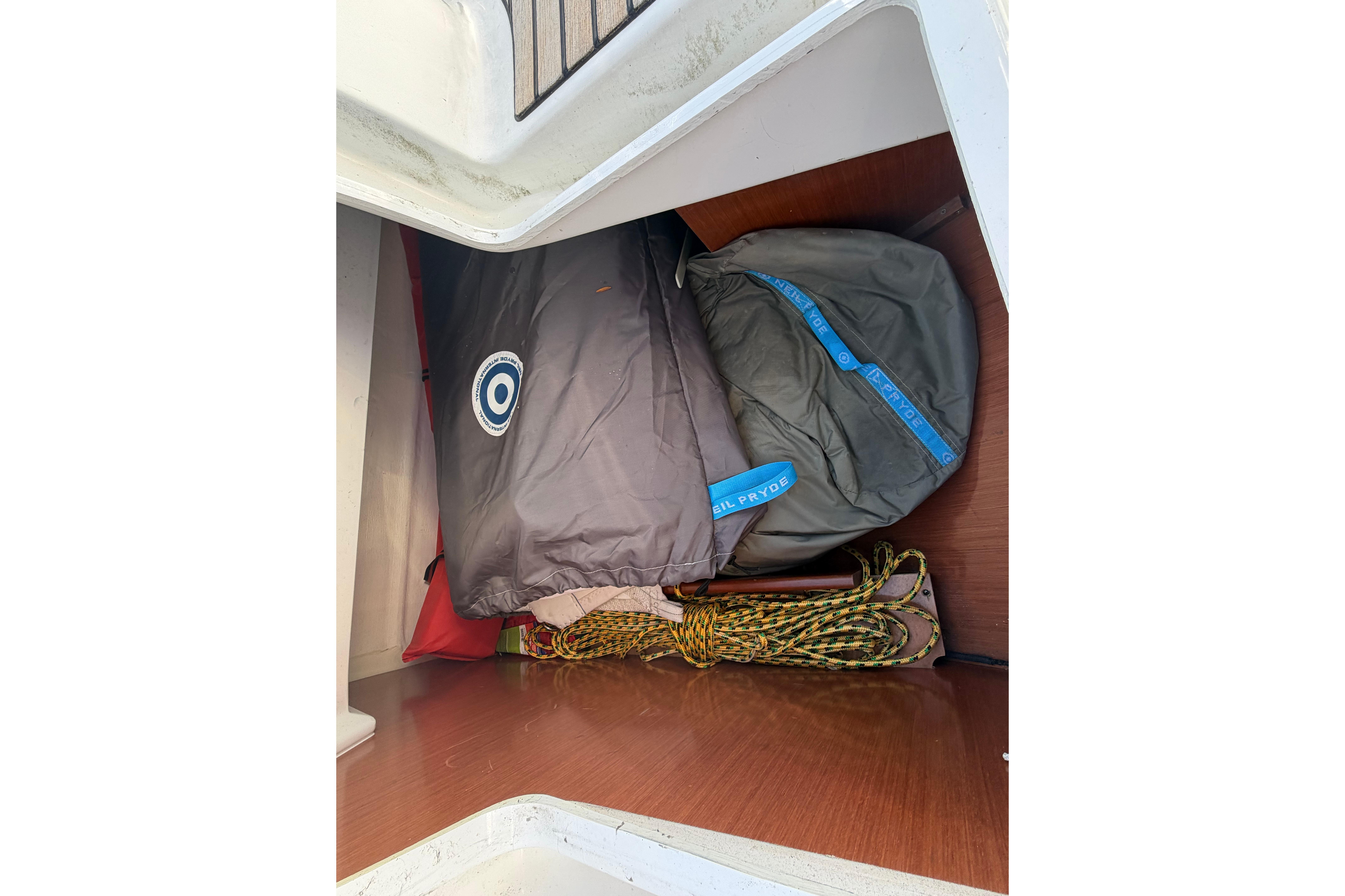 Storage compartment on a 2008 Beneteau 31 sailboat with sailing gear and ropes.