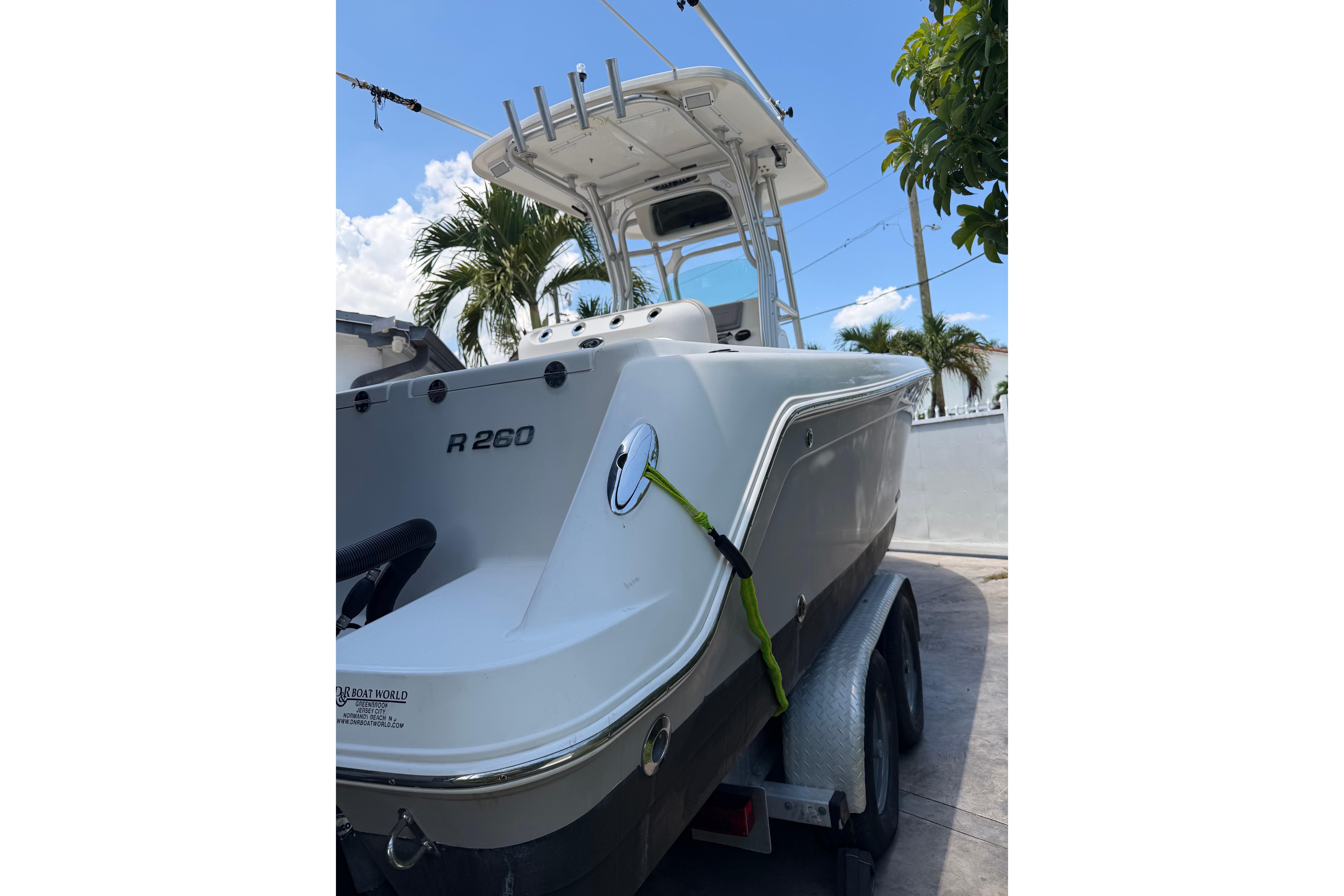 2007 Robalo R260 Center Console boat on trailer, palm trees in background.