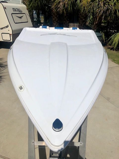 2003 Baja 20 Outlaw with a sleek white hull, parked on a trailer.