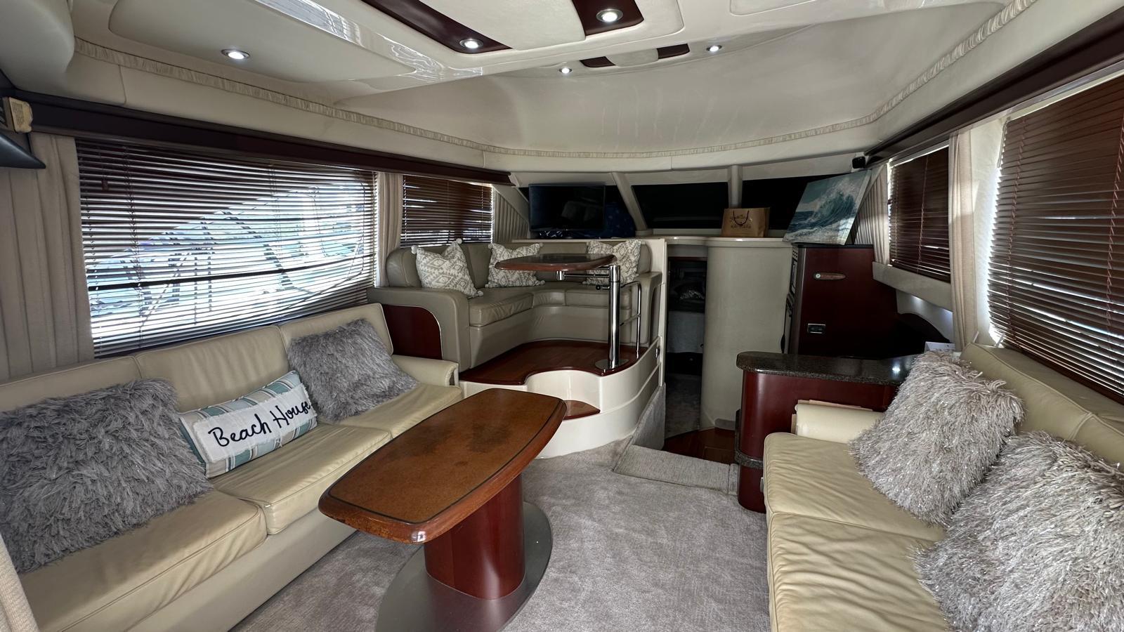 Luxurious interior of 2006 Sea Ray 44 Sedan Bridge yacht with plush seating and wooden accents.