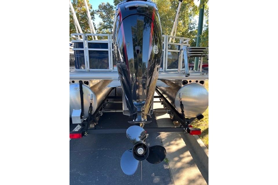 2026 Sun Tracker SportFish 22 DLX pontoon boat with outboard motor, rear view.