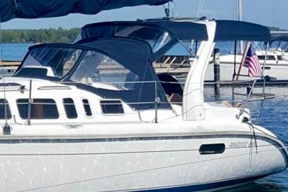 1998 Hunter 340 sailboat docked at a marina with an American flag.