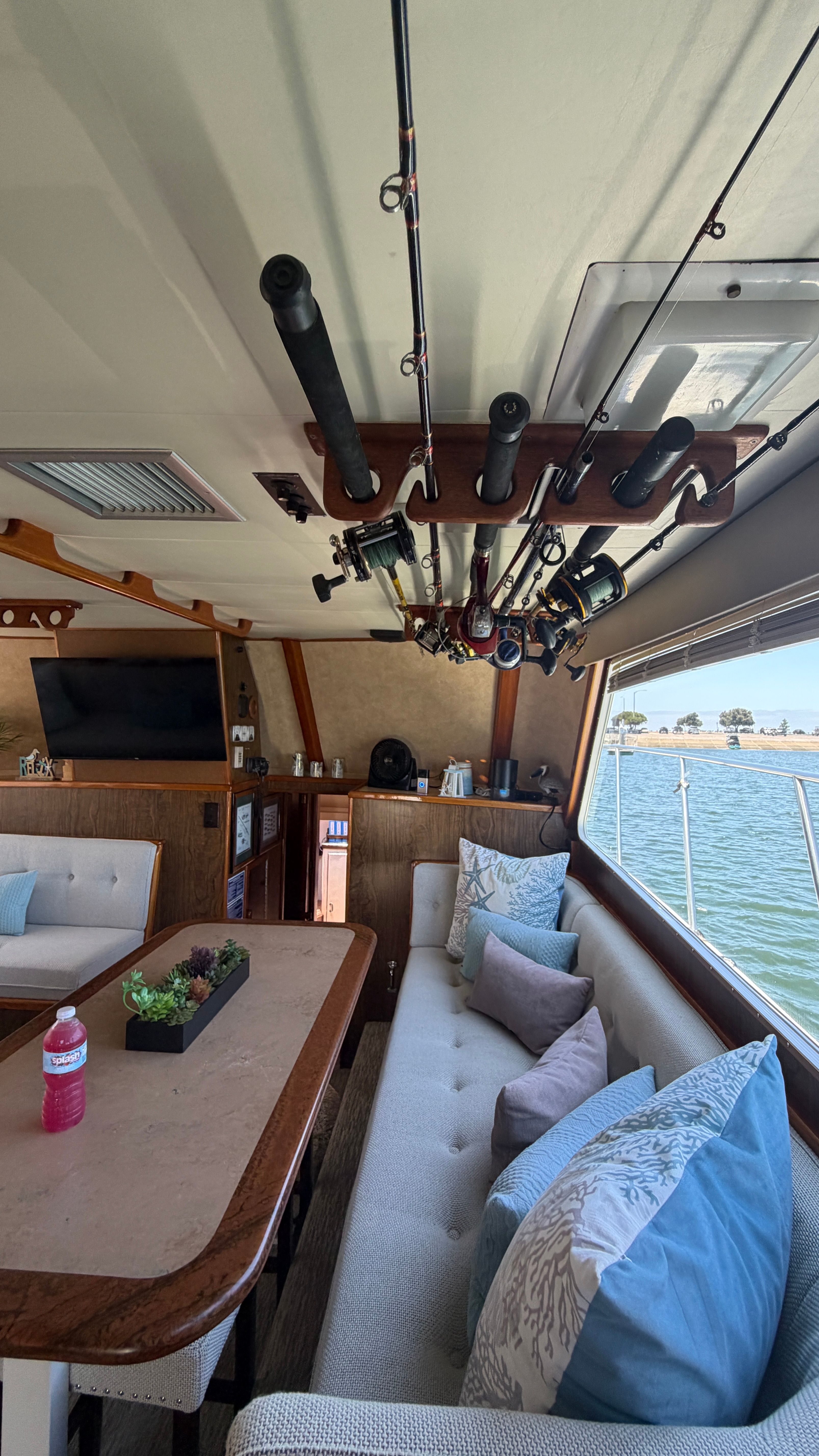 Interior of a 1966 Drake Yachtfisher with fishing rods and cozy seating area.