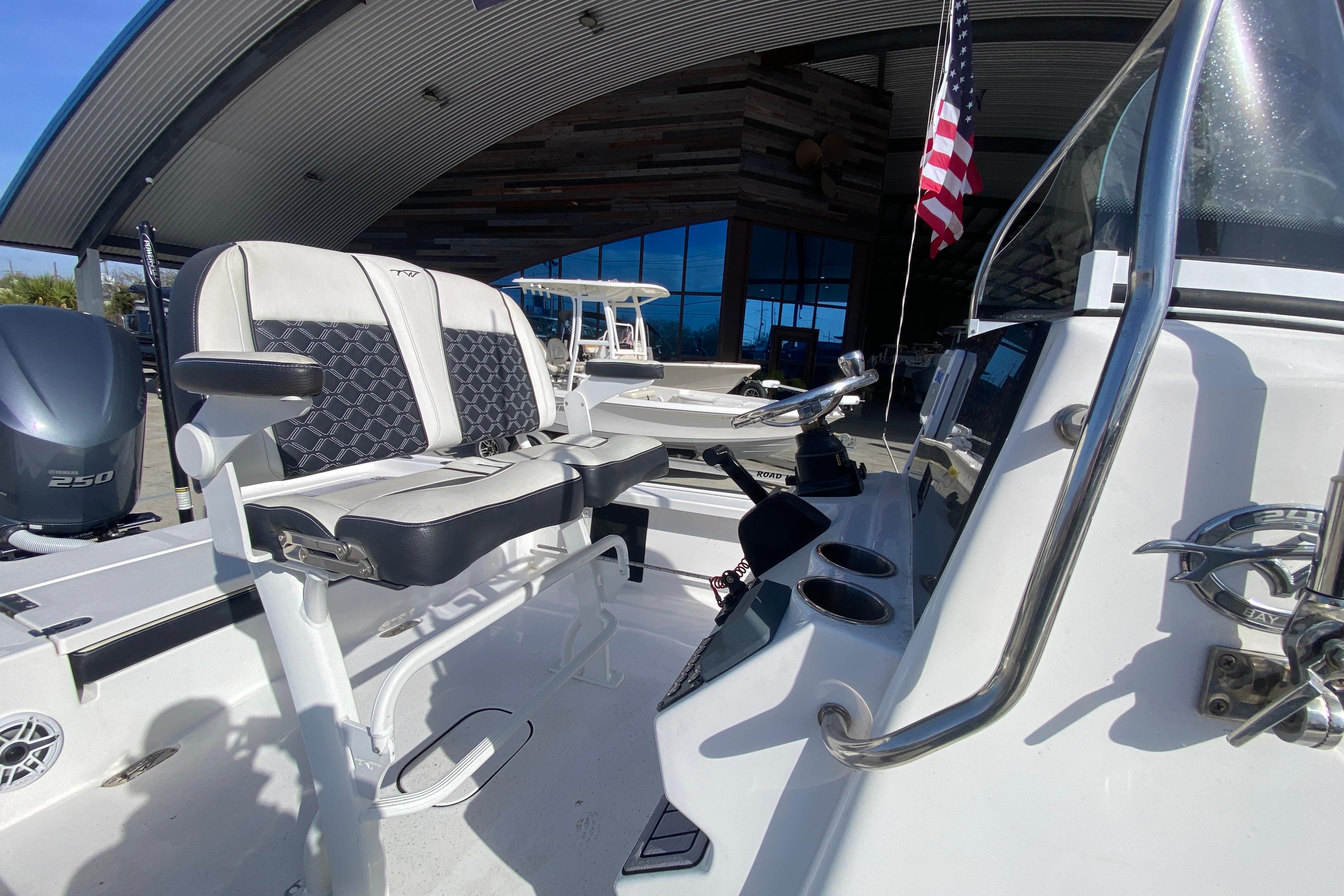 2023 Tidewater 2410 Bay Max boat interior with seating and controls, docked under a modern canopy.