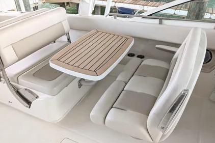 2017 Boston Whaler 320 Vantage interior with cushioned seating and wooden table.