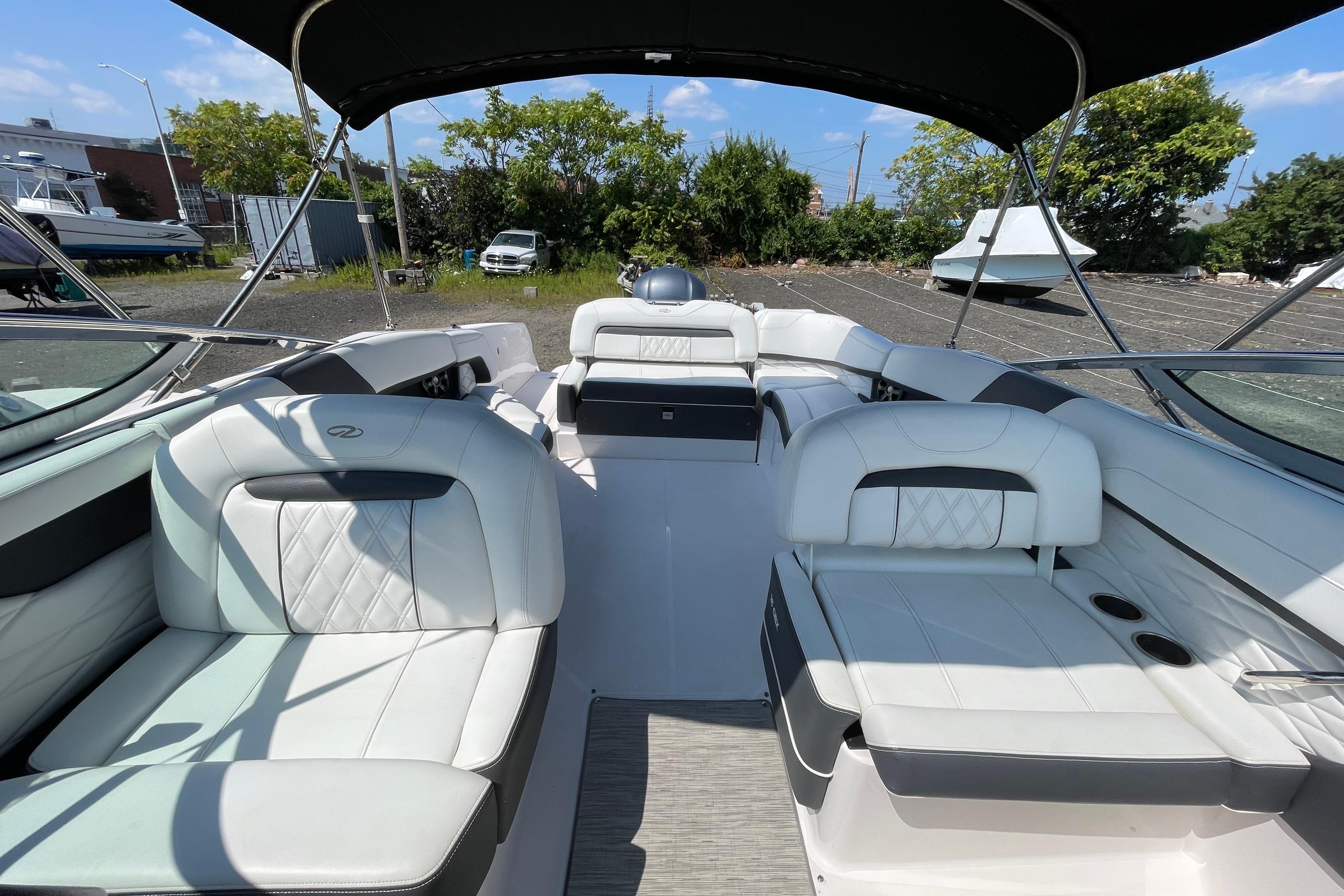 2018 Regal 26 OBX boat interior with white seating and canopy, parked outdoors.