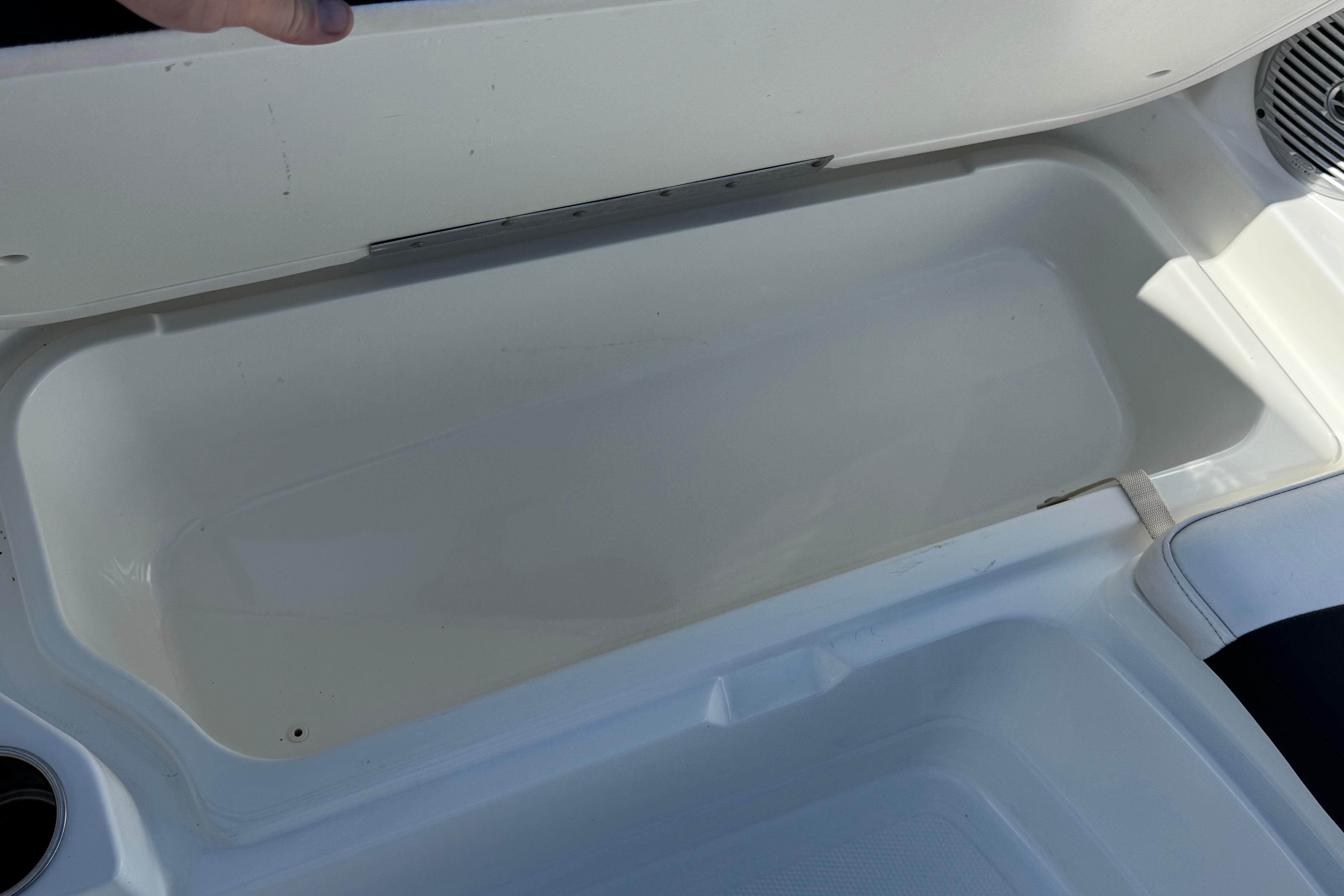 Open storage compartment in 2019 Tahoe 2150 boat, featuring white interior.