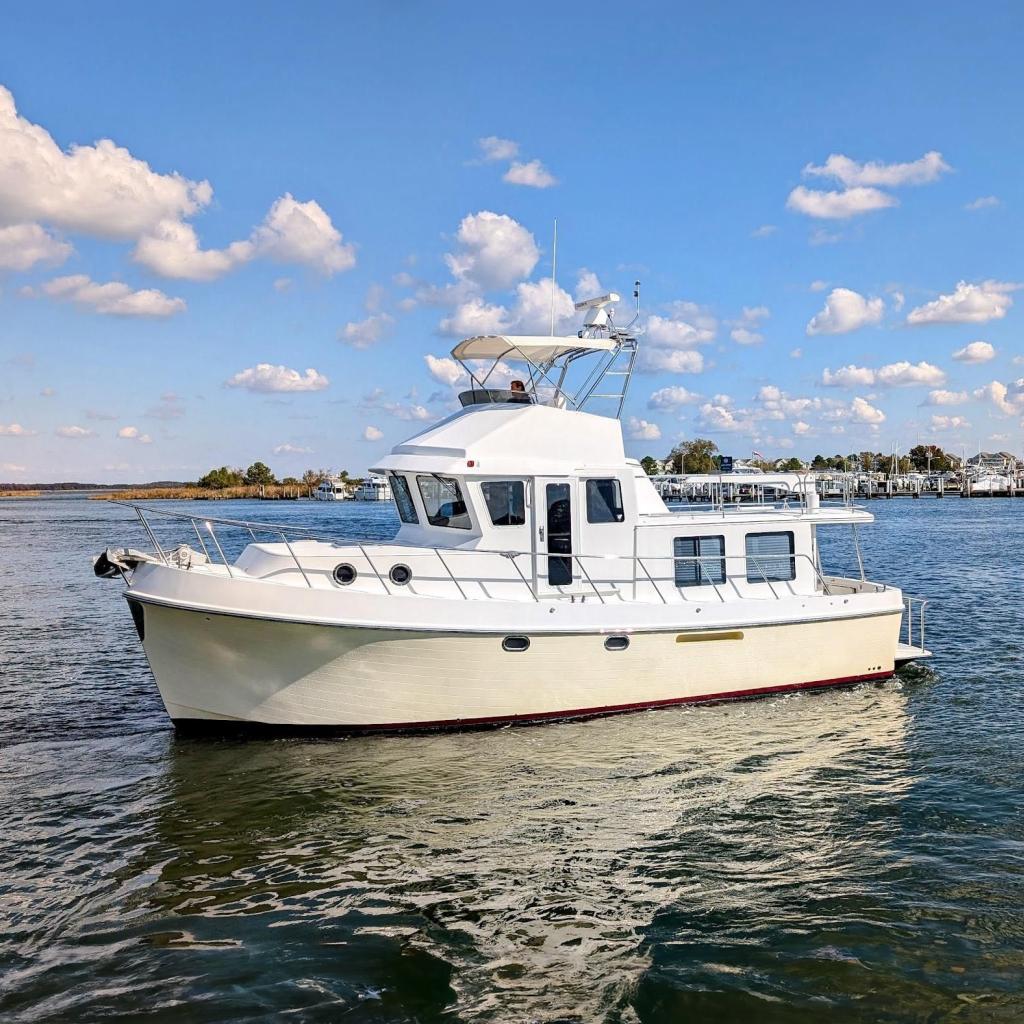 2015 American Tug 435 cruising on a sunny day with blue skies and calm waters.