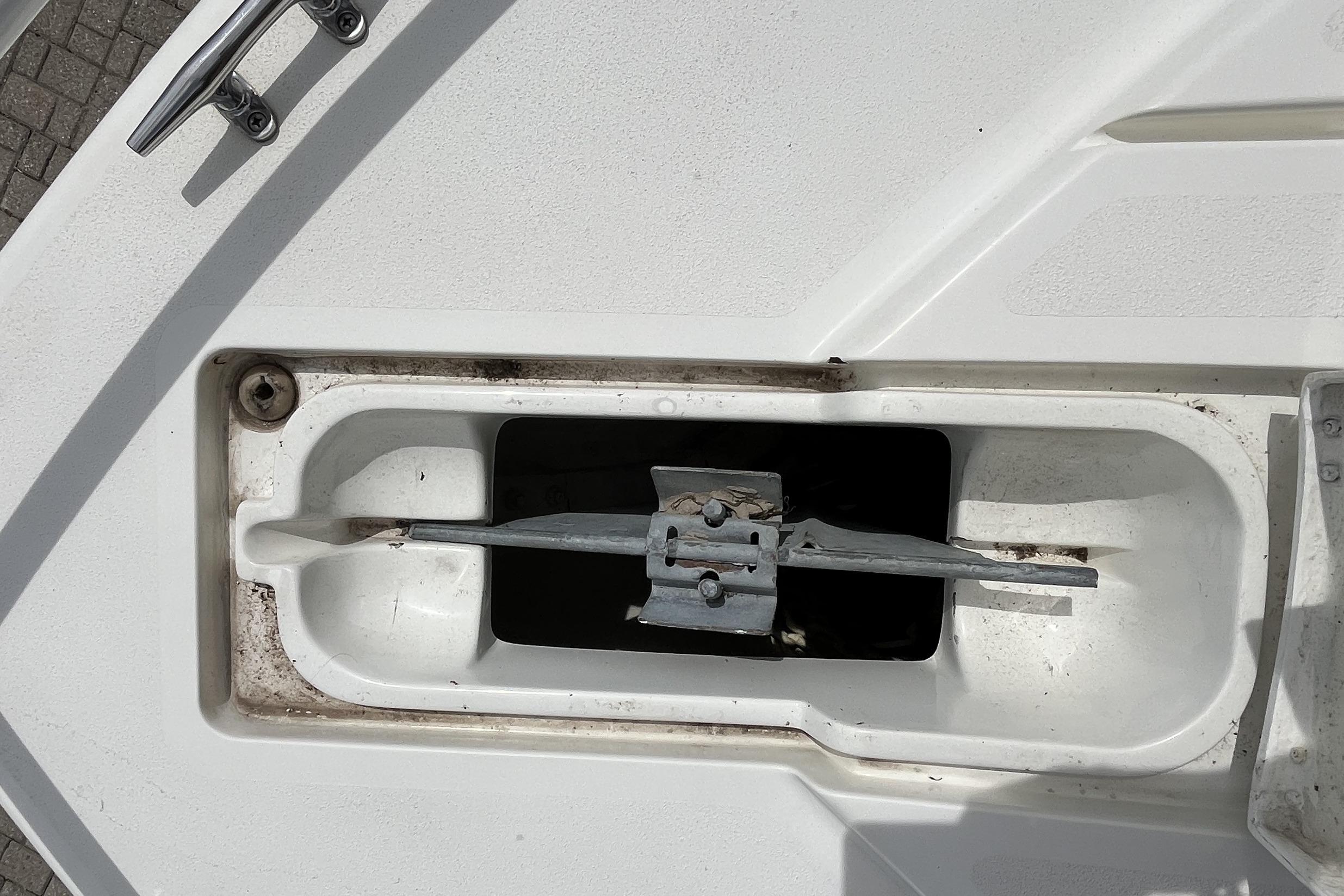 Anchor compartment of a 1994 Intrepid 30 Open Cuddy boat, showing metal cleat and anchor.
