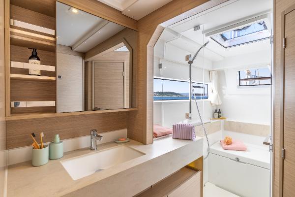 Luxurious bathroom interior of 2025 Lagoon 43 yacht with modern fixtures and natural light.