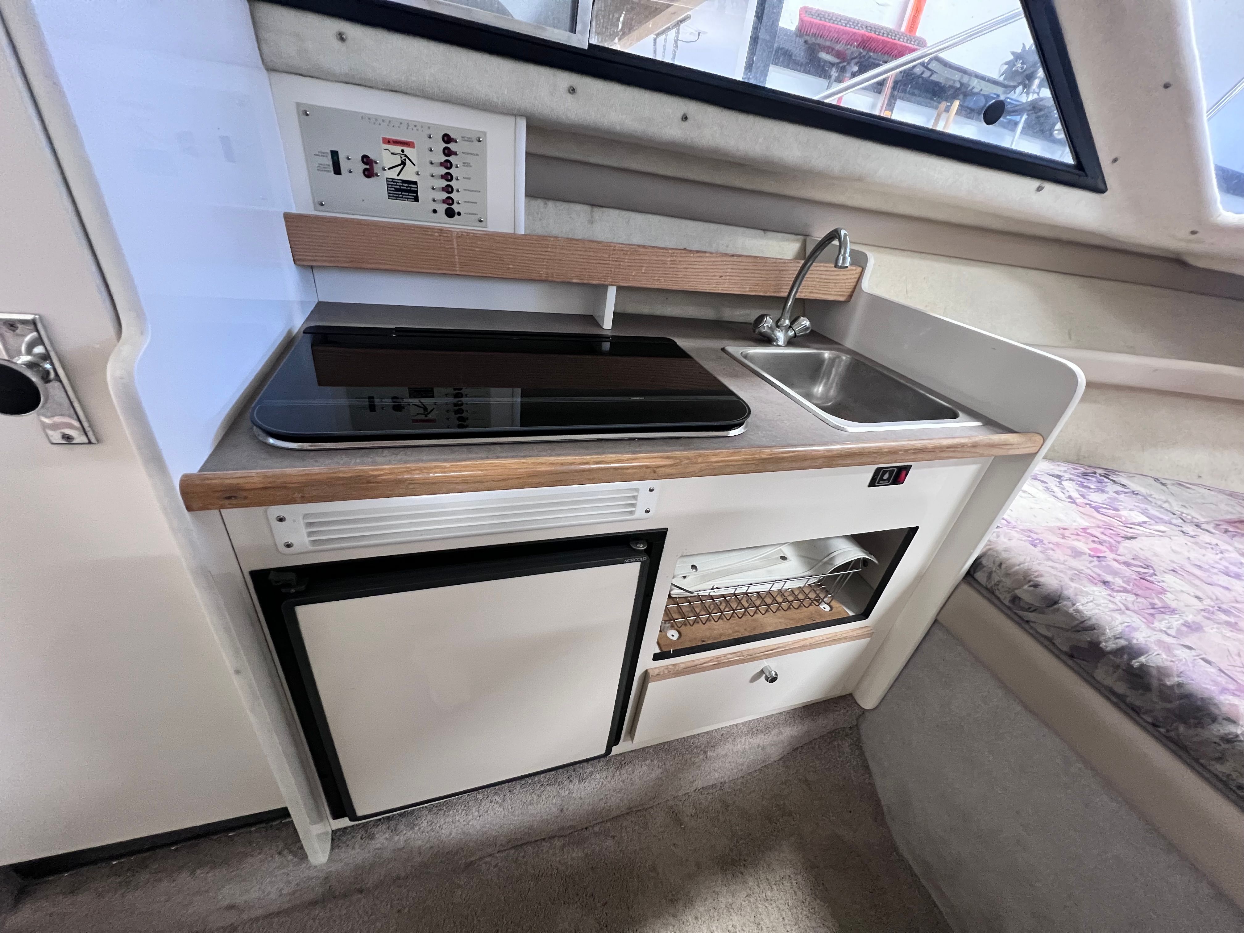 1997 Bayliner 2452 kitchenette with sink and stove.