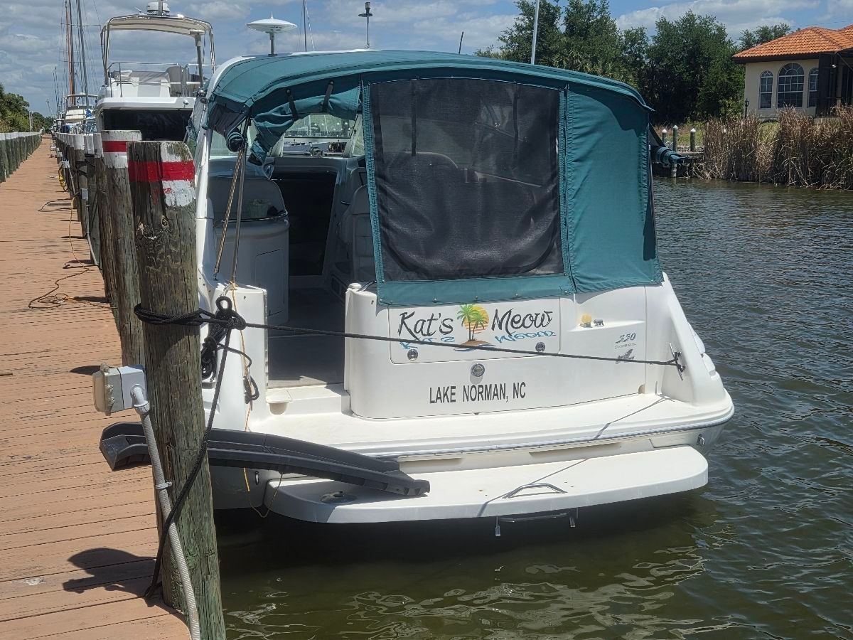 1995 Sea Ray Sundancer 330 docked with green canopy and "Kat's Meow" lettering.