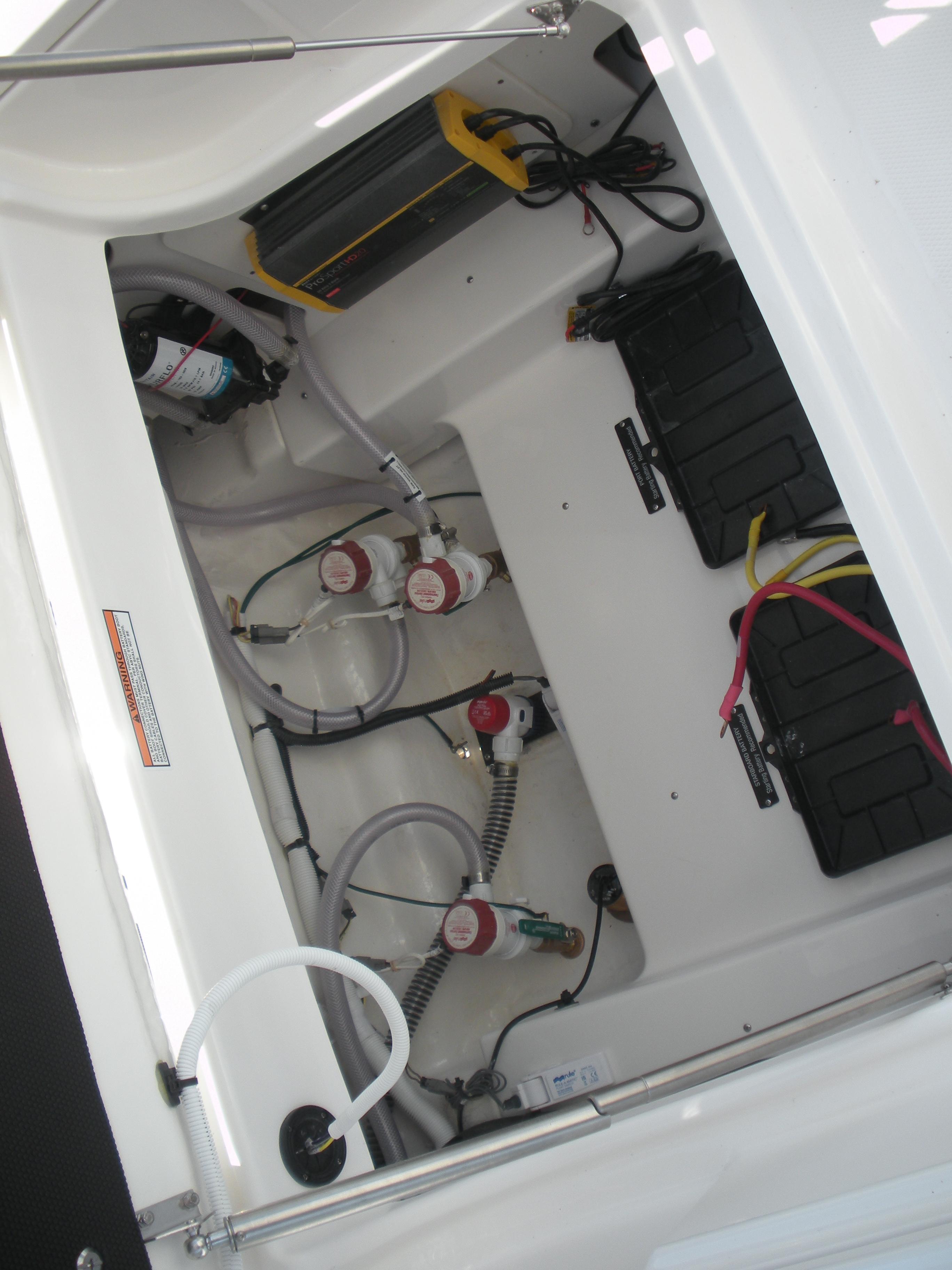 2026 Robalo R246 Caymann boat interior showing battery compartment and wiring.