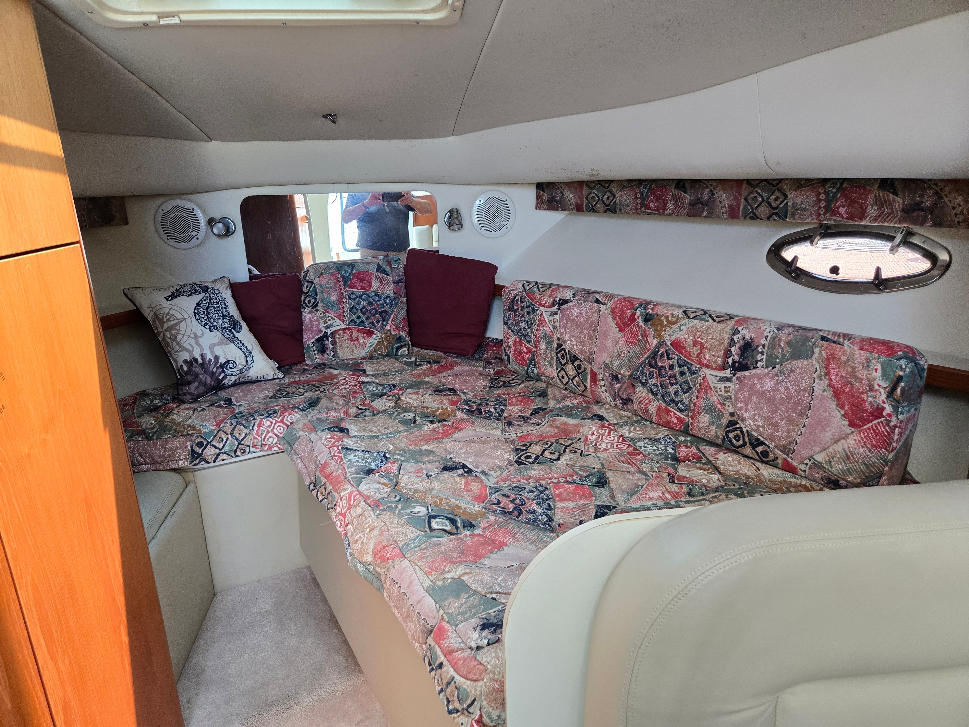 Interior of a 1997 Tiara Yachts Open with patterned upholstery and a porthole.