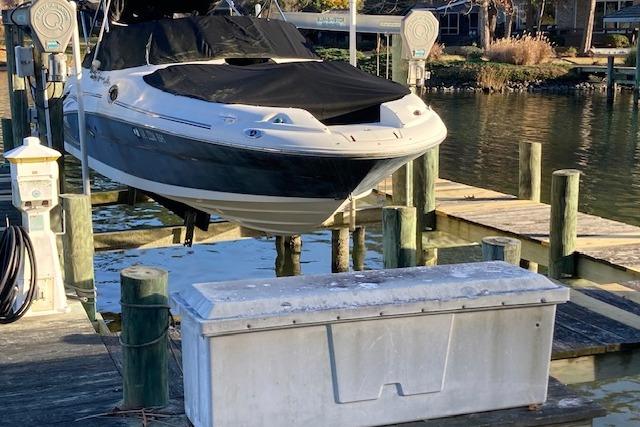 2006 Sea Ray 270 Sundeck boat on lift at dockside, covered and ready for storage.