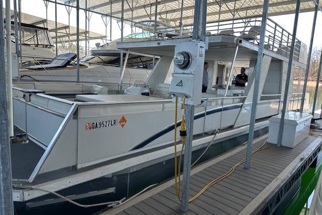 2008 Destination Yachts 45X14 houseboat docked in a marina under a covered slip.