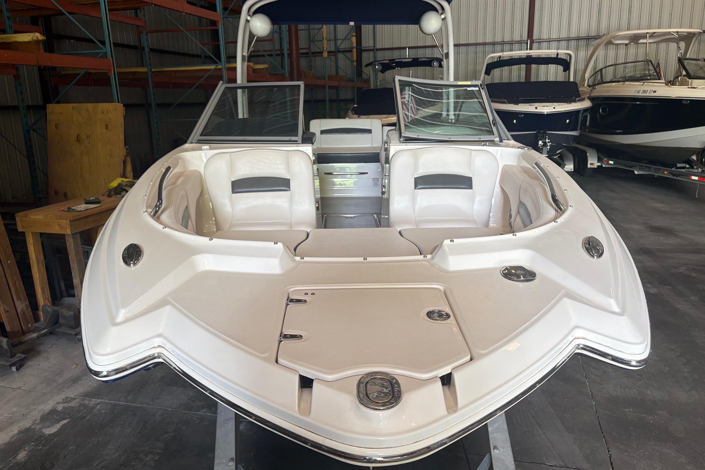 2016 Chaparral 244 Sunesta boat in storage, showcasing sleek design and spacious seating.