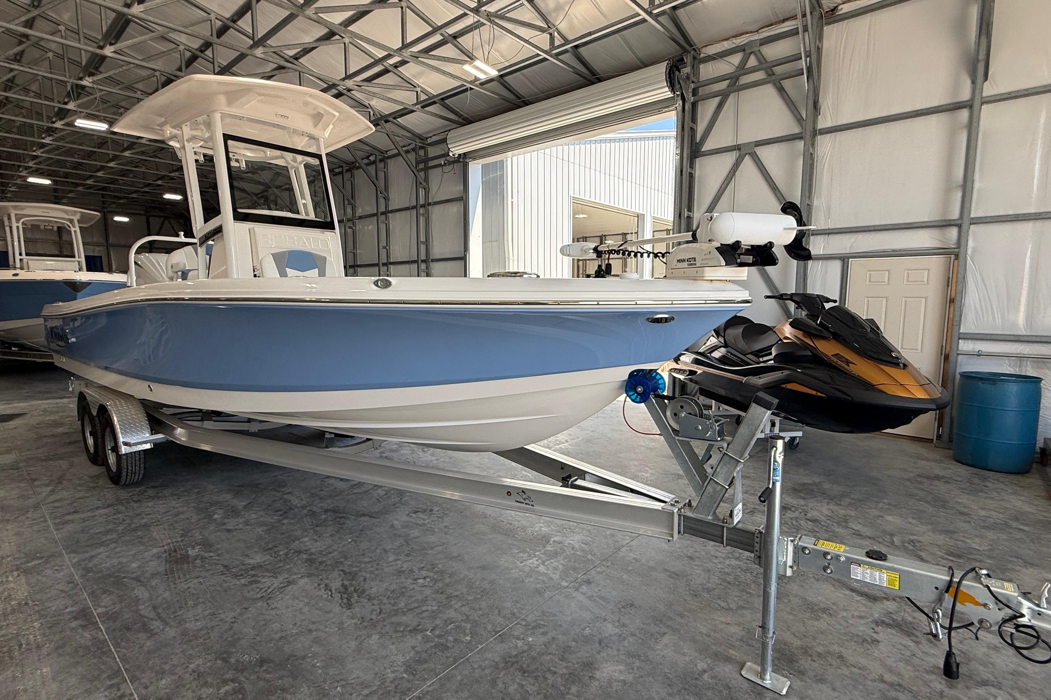 2026 Robalo 246 Cayman boat in a storage facility, featuring a sleek blue and white design.