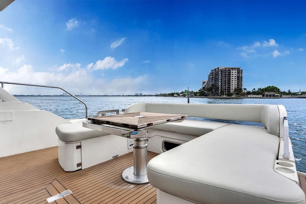 Luxurious 2012 Fairline Targa 58 yacht deck with seating, overlooking serene waterfront and skyline.