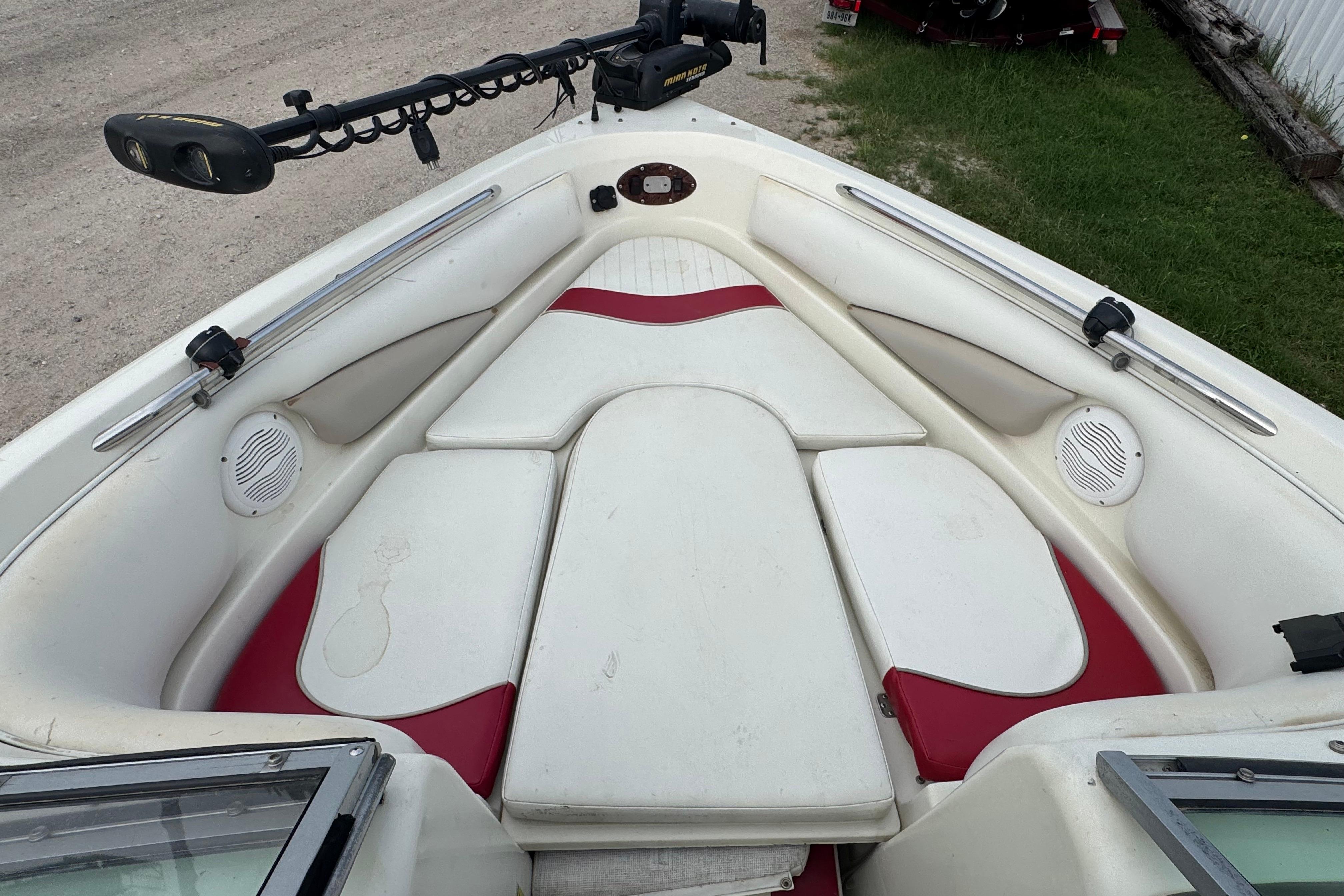 2006 Caravelle 207LS Bow Rider interior with white and red seating, featuring speakers and a trolling motor.