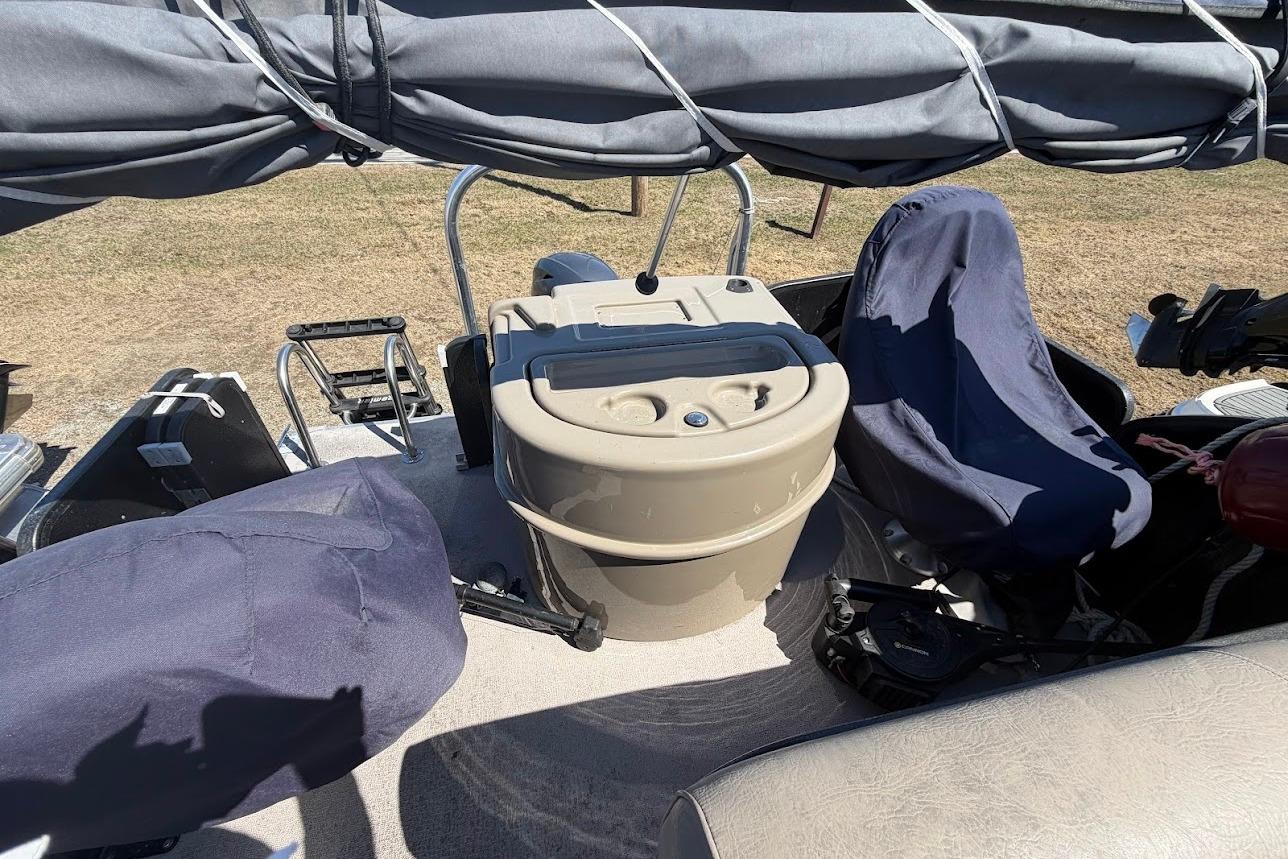 2013 Premier 221 Explorer boat interior with covered seats and helm station.