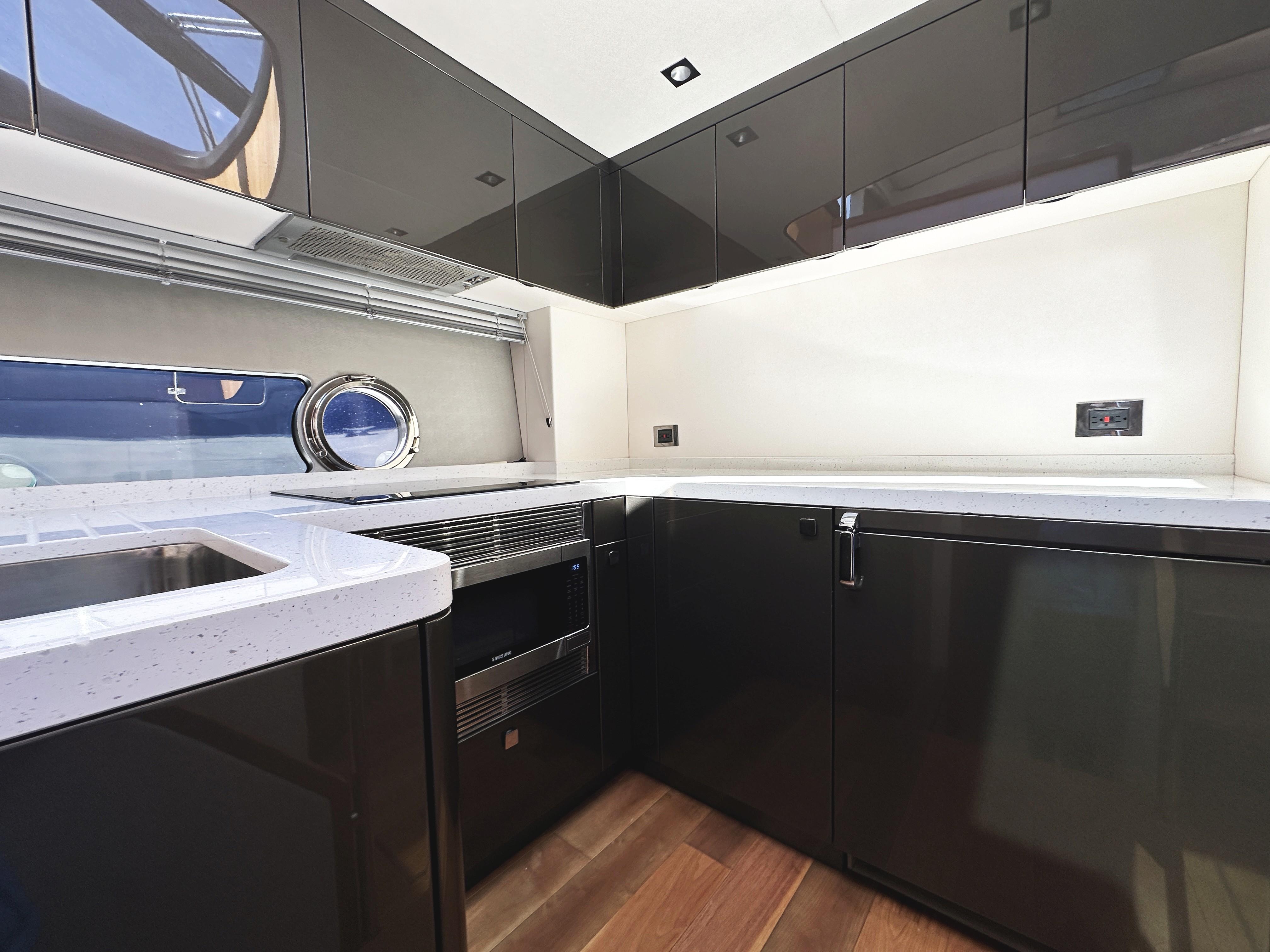 Modern kitchen interior on 2019 Sunseeker Predator 57 yacht, featuring sleek cabinetry and appliances.