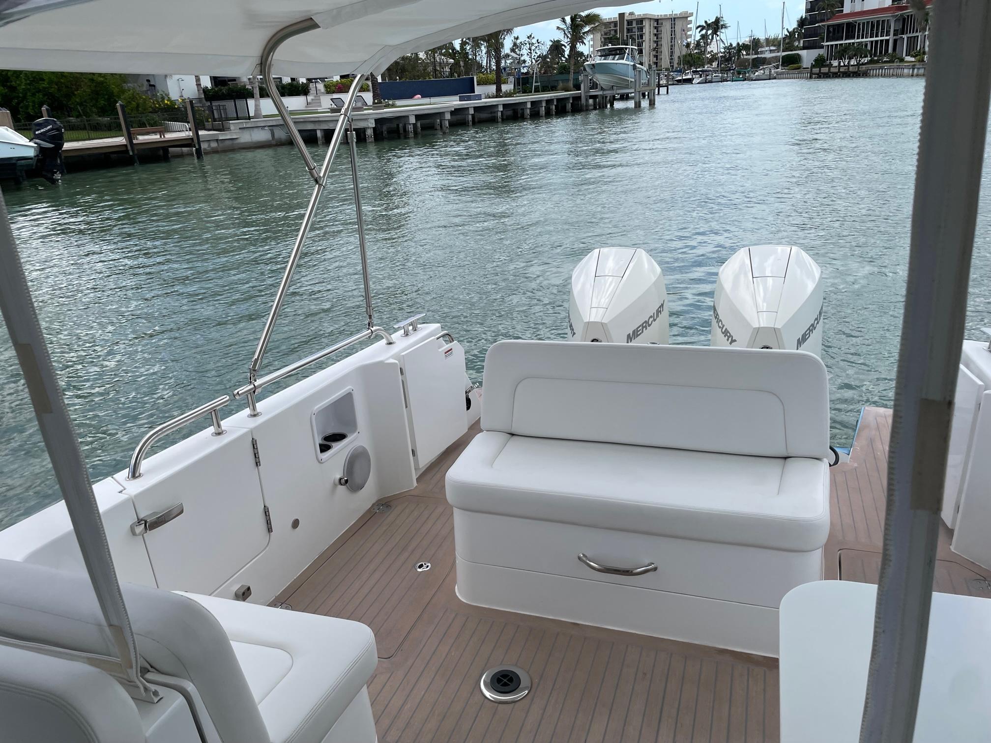 2023 MJM 35z boat with twin engines, docked on a calm waterfront.