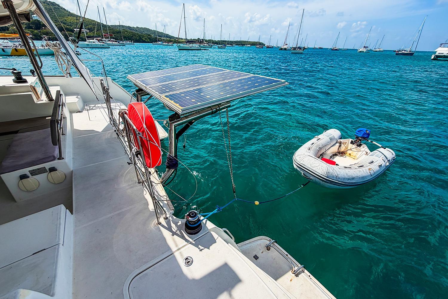 Lagoon 400 catamaran with solar panels and dinghy in a scenic marina, 2010 model.