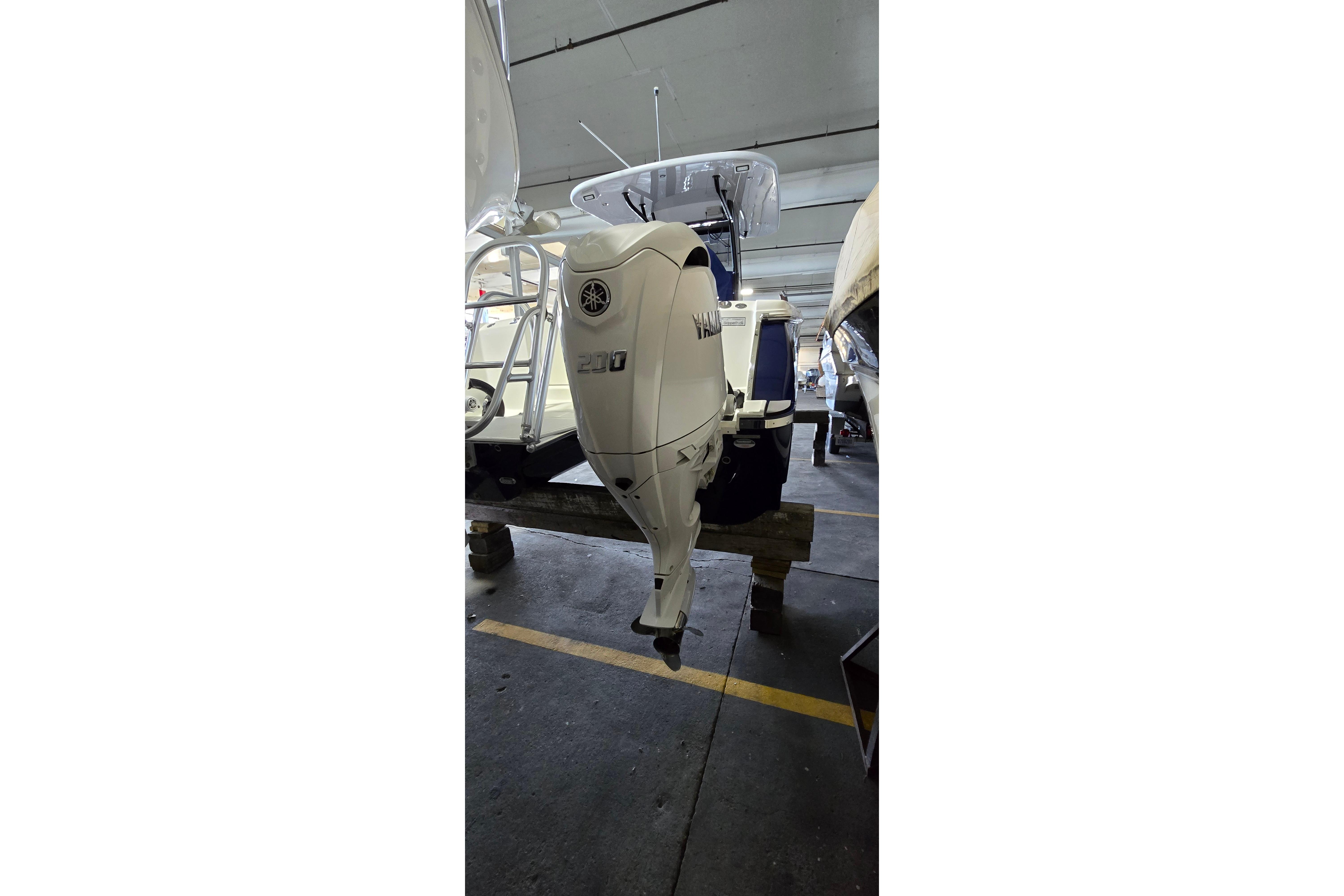 2024 WorldCat 280 CC-X boat with Yamaha 200 outboard motor in storage.