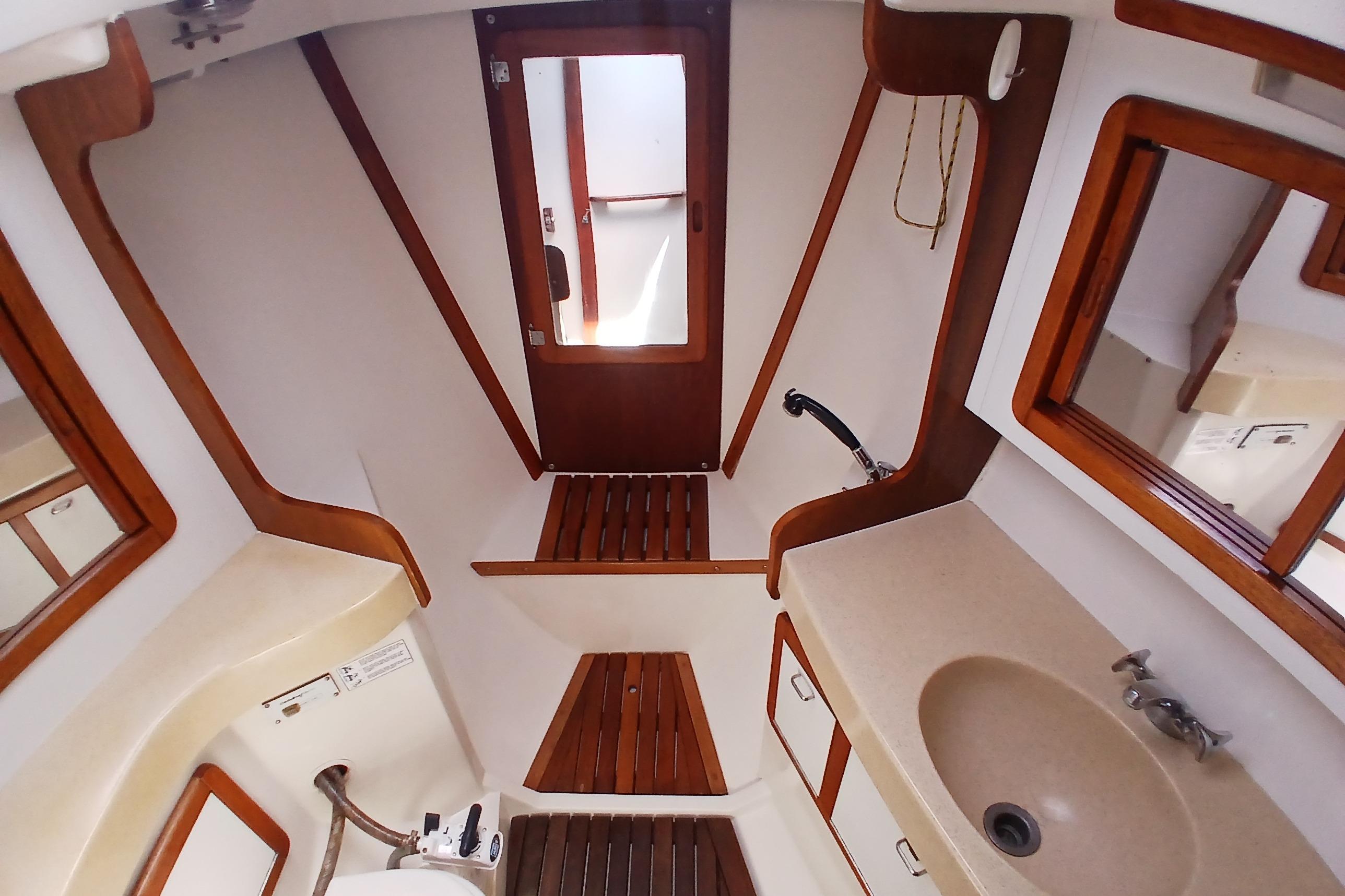 Interior of 1995 Catalina 42 MkII sailboat bathroom with wooden accents and sink.