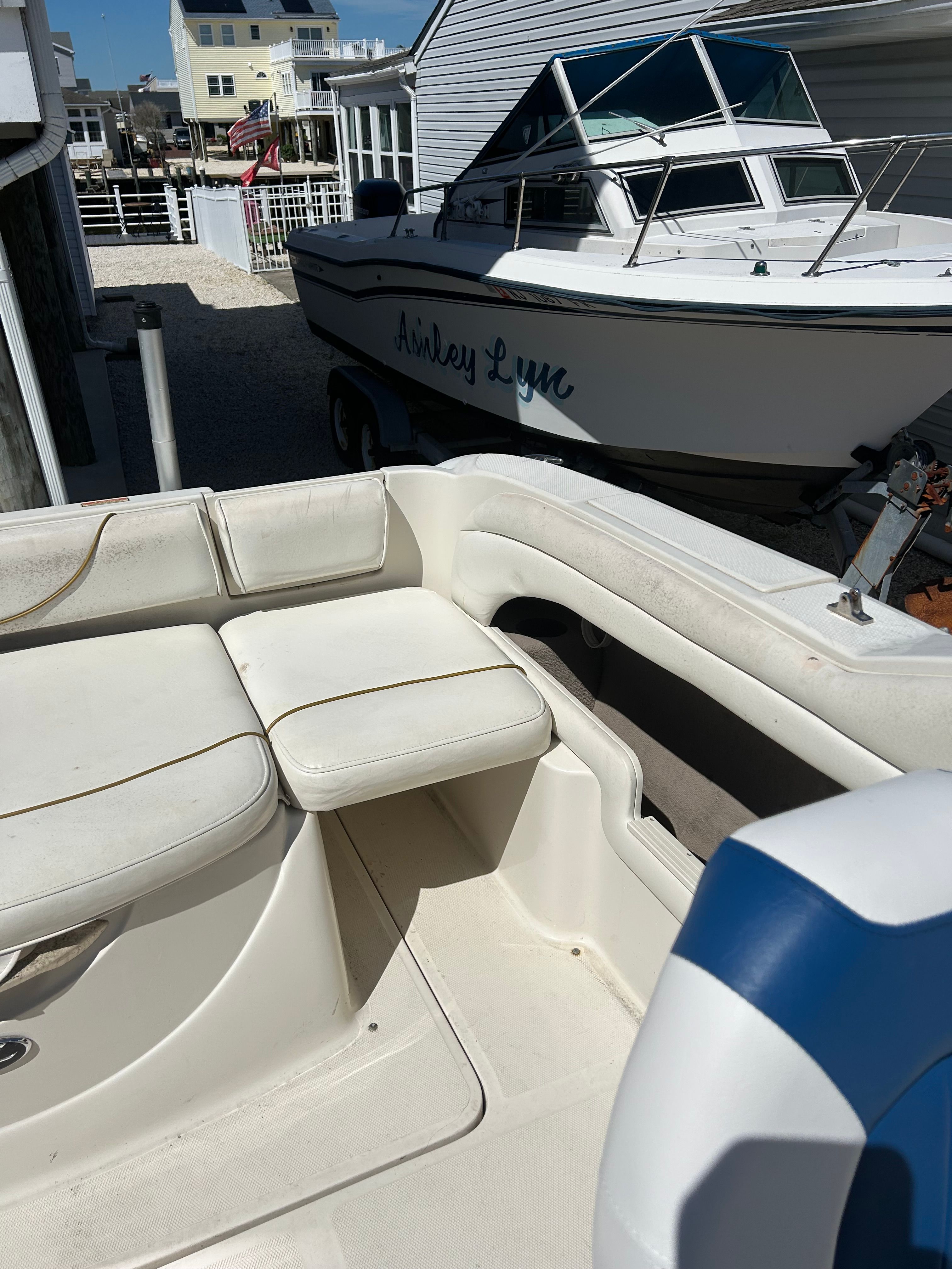 The image shows the cockpit of a 2002 Sea Ray 225 Weekender with white upholstery.