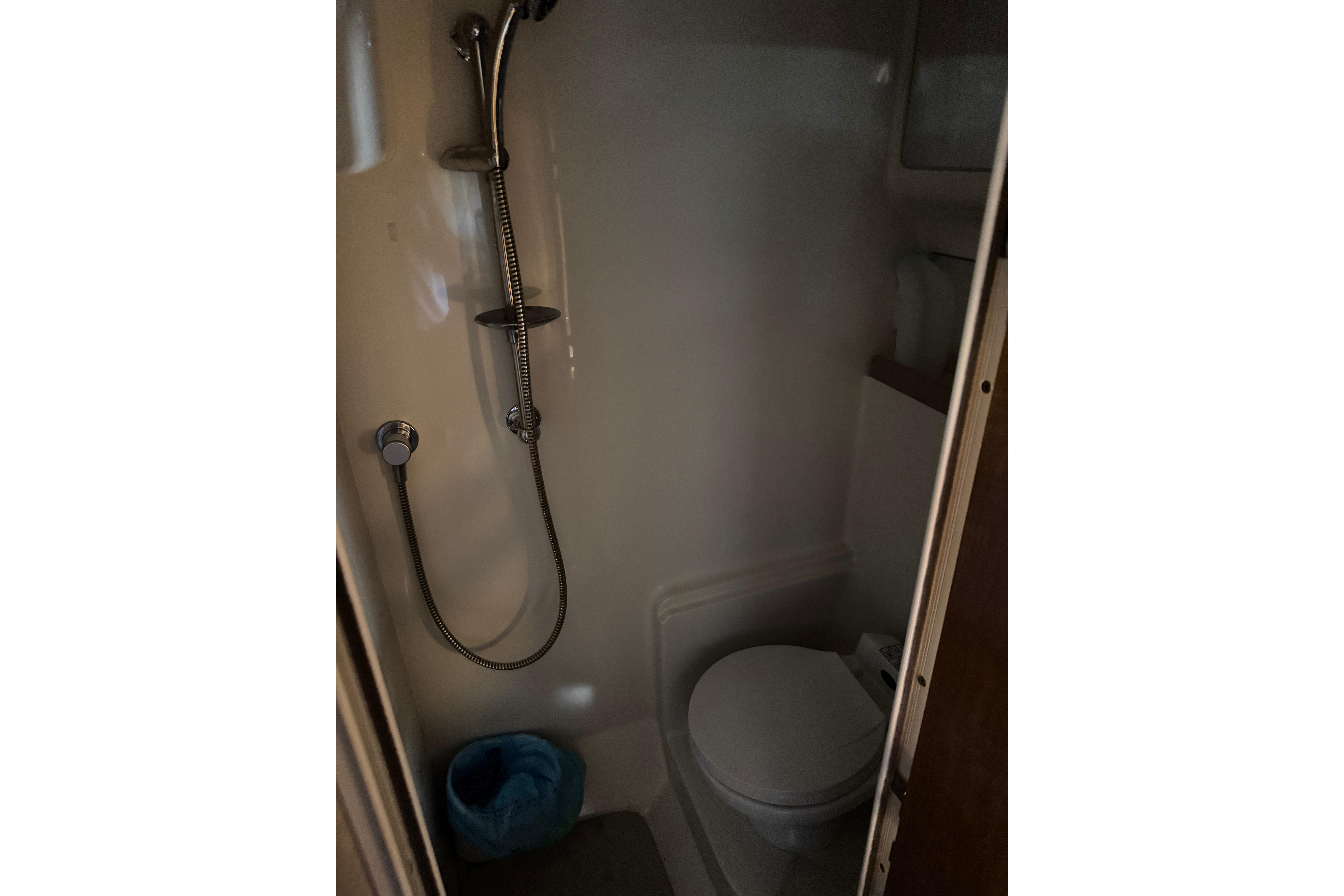 Compact bathroom in 2007 Regal Commodore 3860 yacht with shower and toilet.