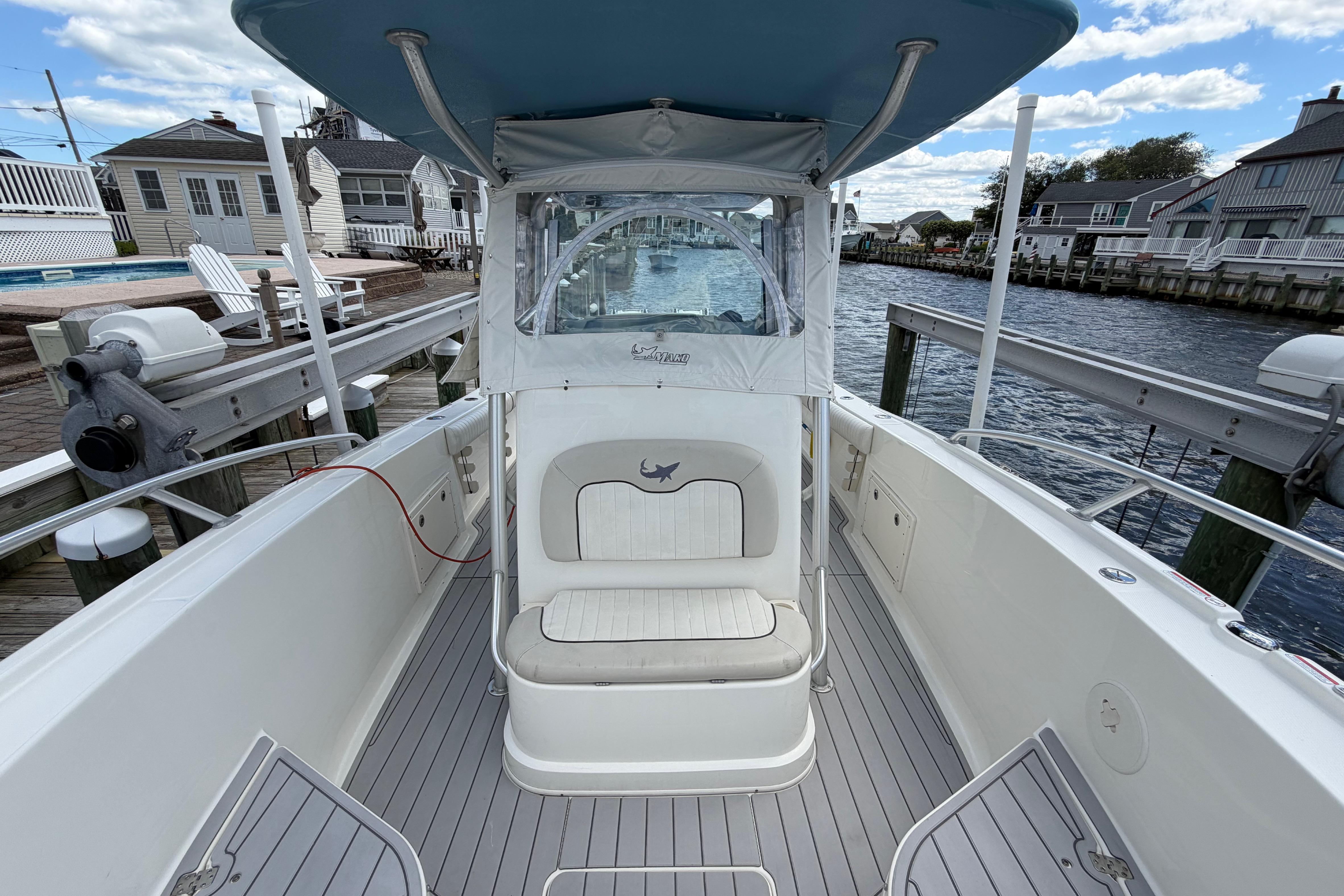 2017 Mako 284 Center Console boat docked by waterfront homes.