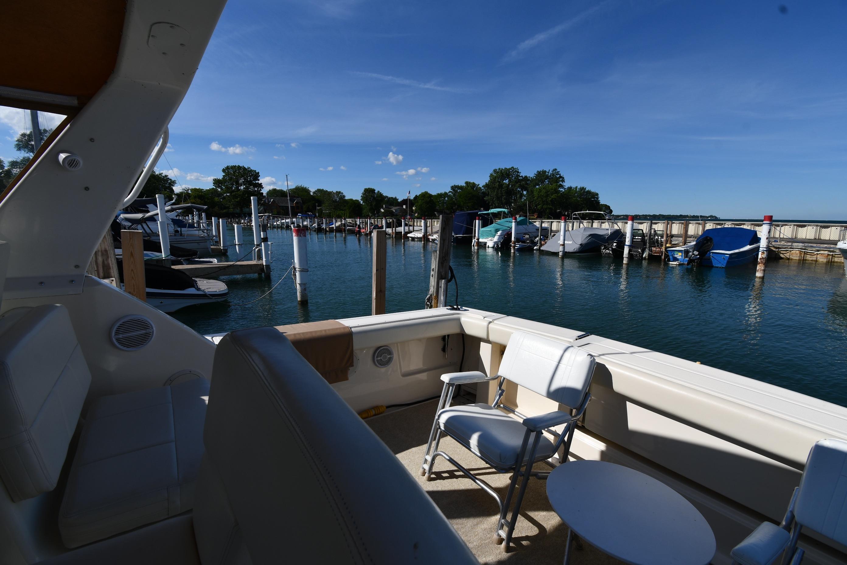 1998 Tiara Yachts 3100 Open at marina, featuring spacious deck and scenic waterfront view.