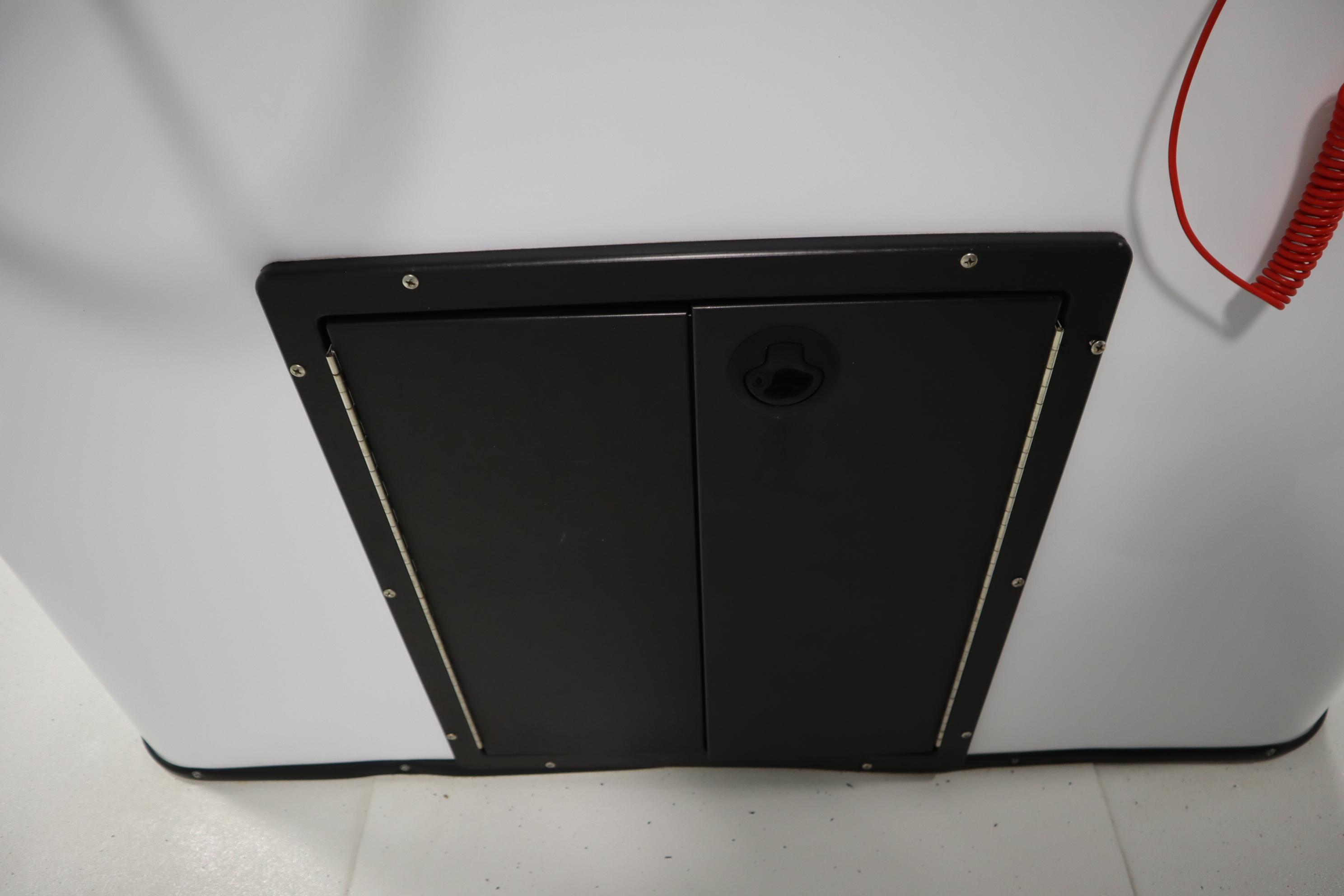 2022 Crestliner 2200 CC boat storage compartment with black panel and red cord.