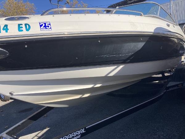 2008 Chaparral 210 SSi boat on trailer, black and white hull, outdoor setting.